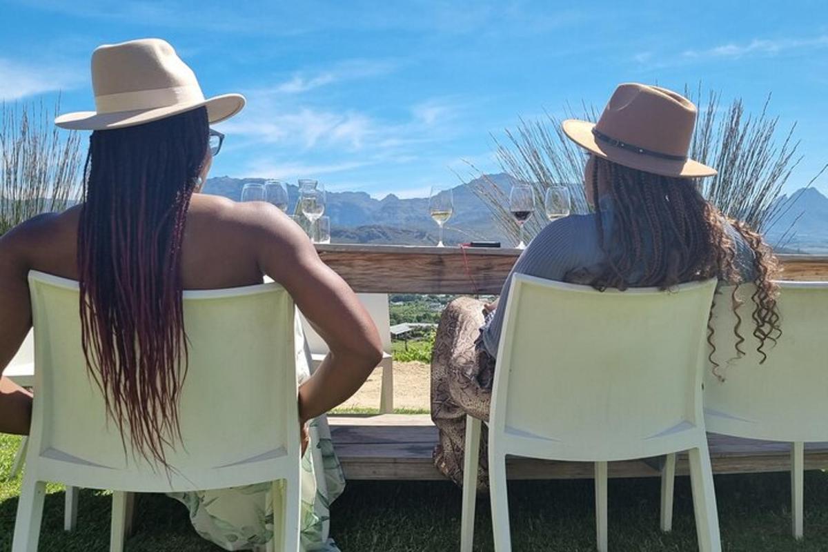 two women sitting in chairs looking out at the ocean