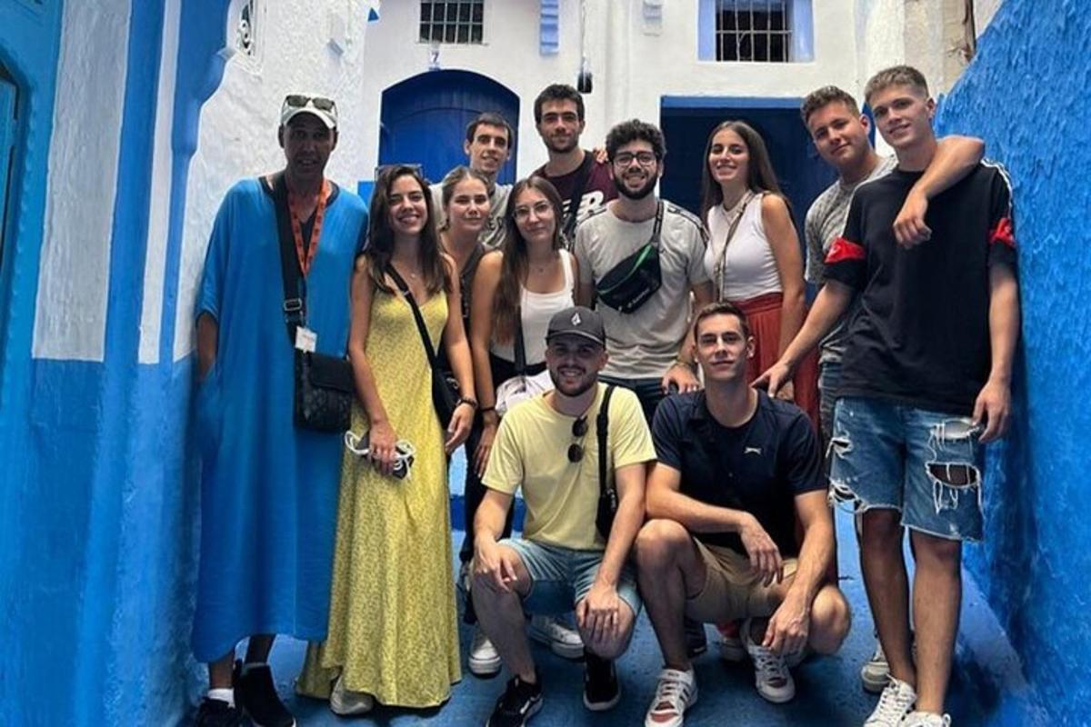 hópur fólks stillir sér upp fyrir mynd fyrir framan byggingu