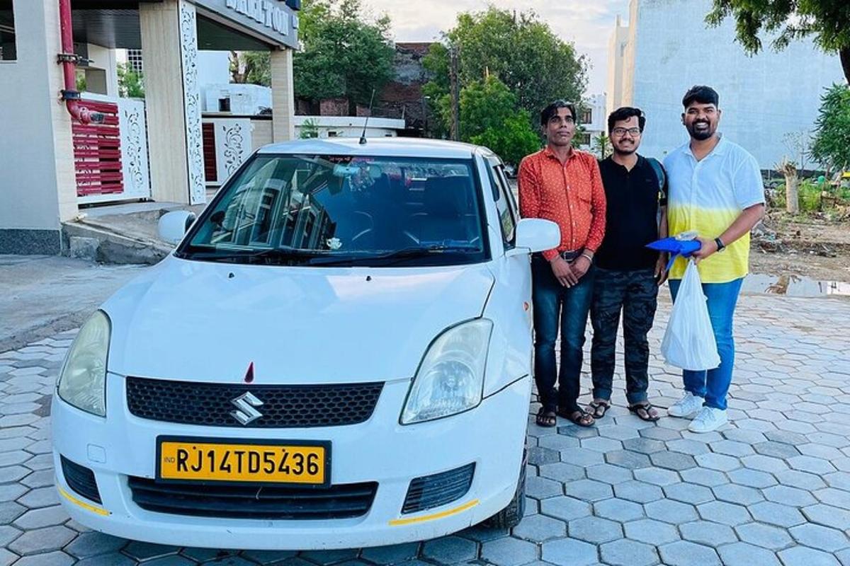 three men are standing next to a white car