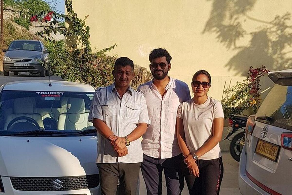 a group of three people standing in front of a car