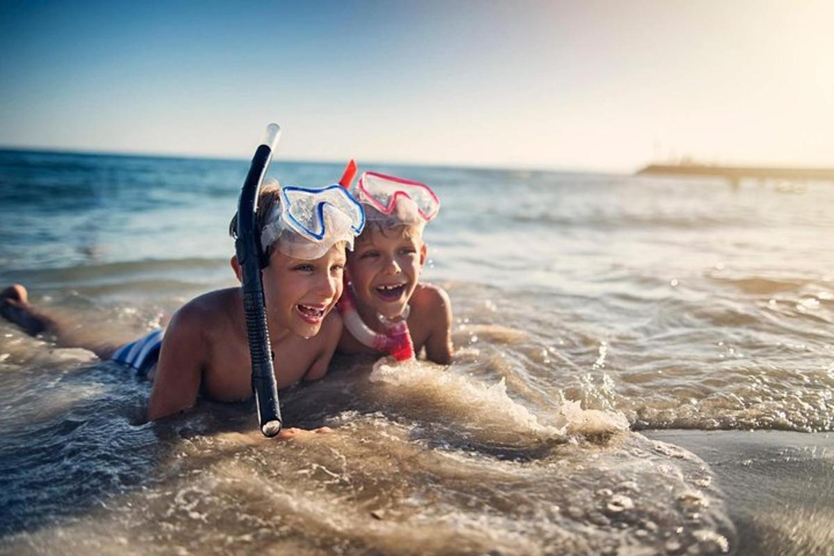 a woman and a child in the water on the beach
