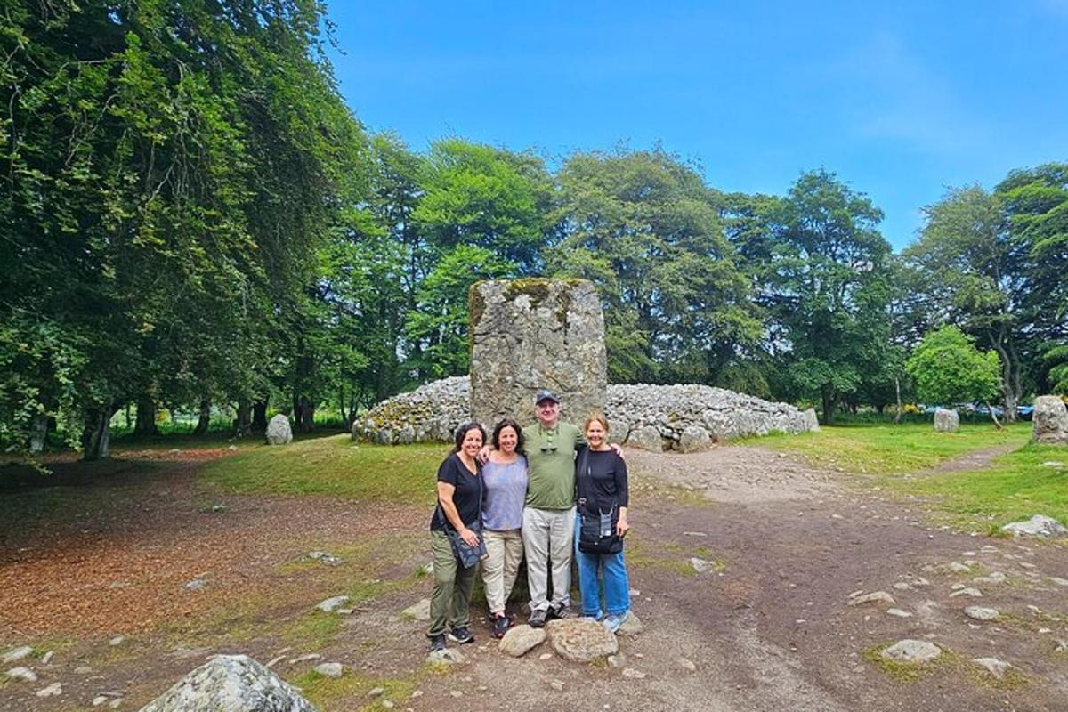 un grup de oameni care stau în fața unui monument de piatră