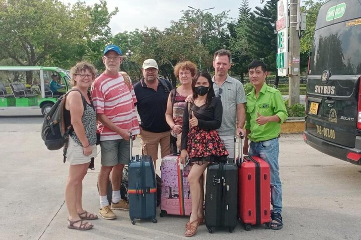 skupina lidí pózujících pro fotografii se zavazadly