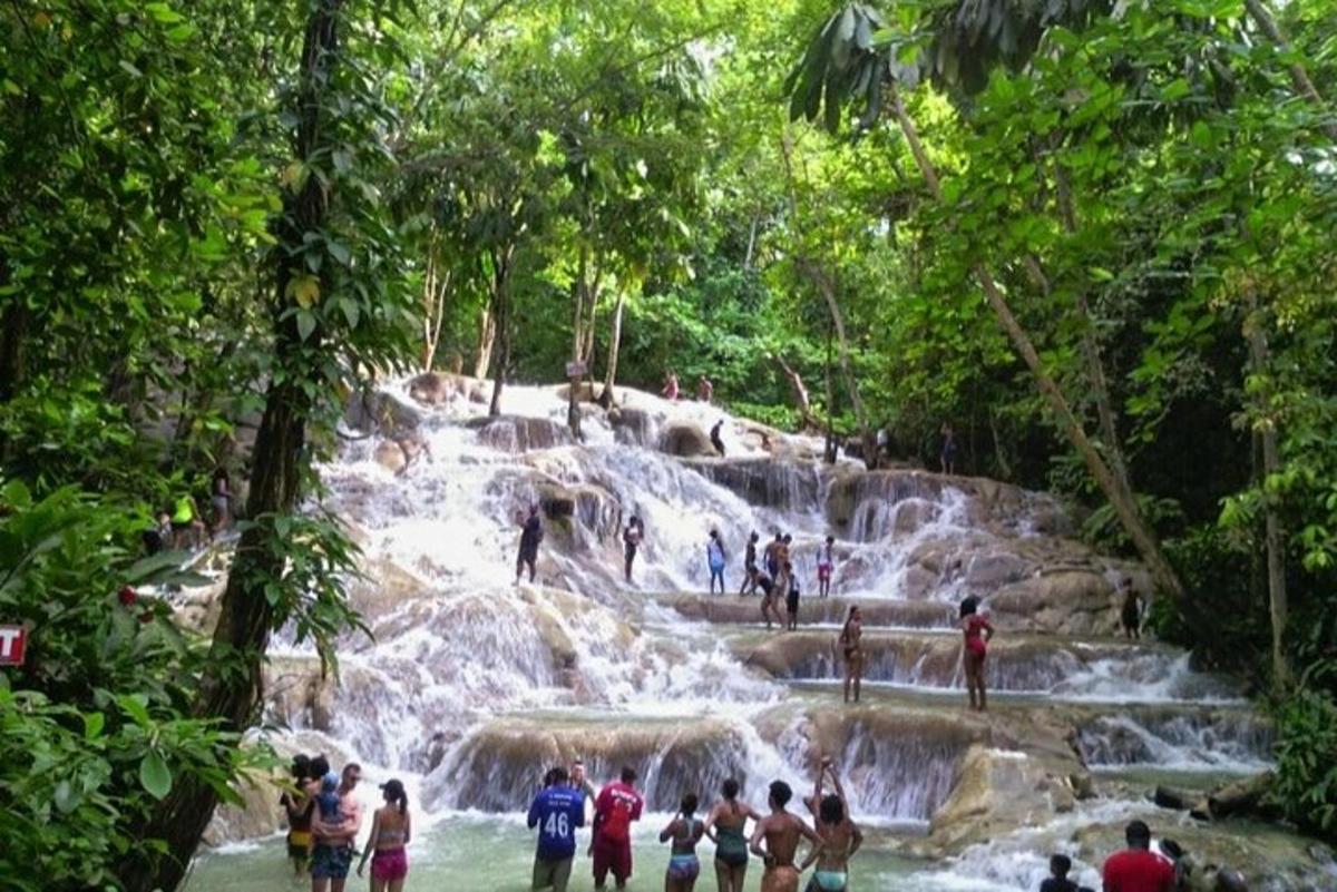 un gruppo di persone in piedi davanti a una cascata