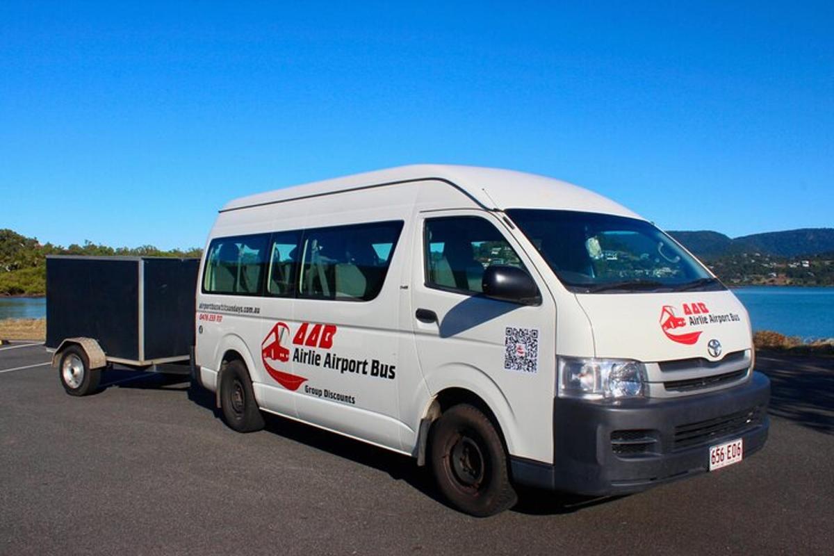 Una camioneta blanca con un remolque estacionado junto a un lago