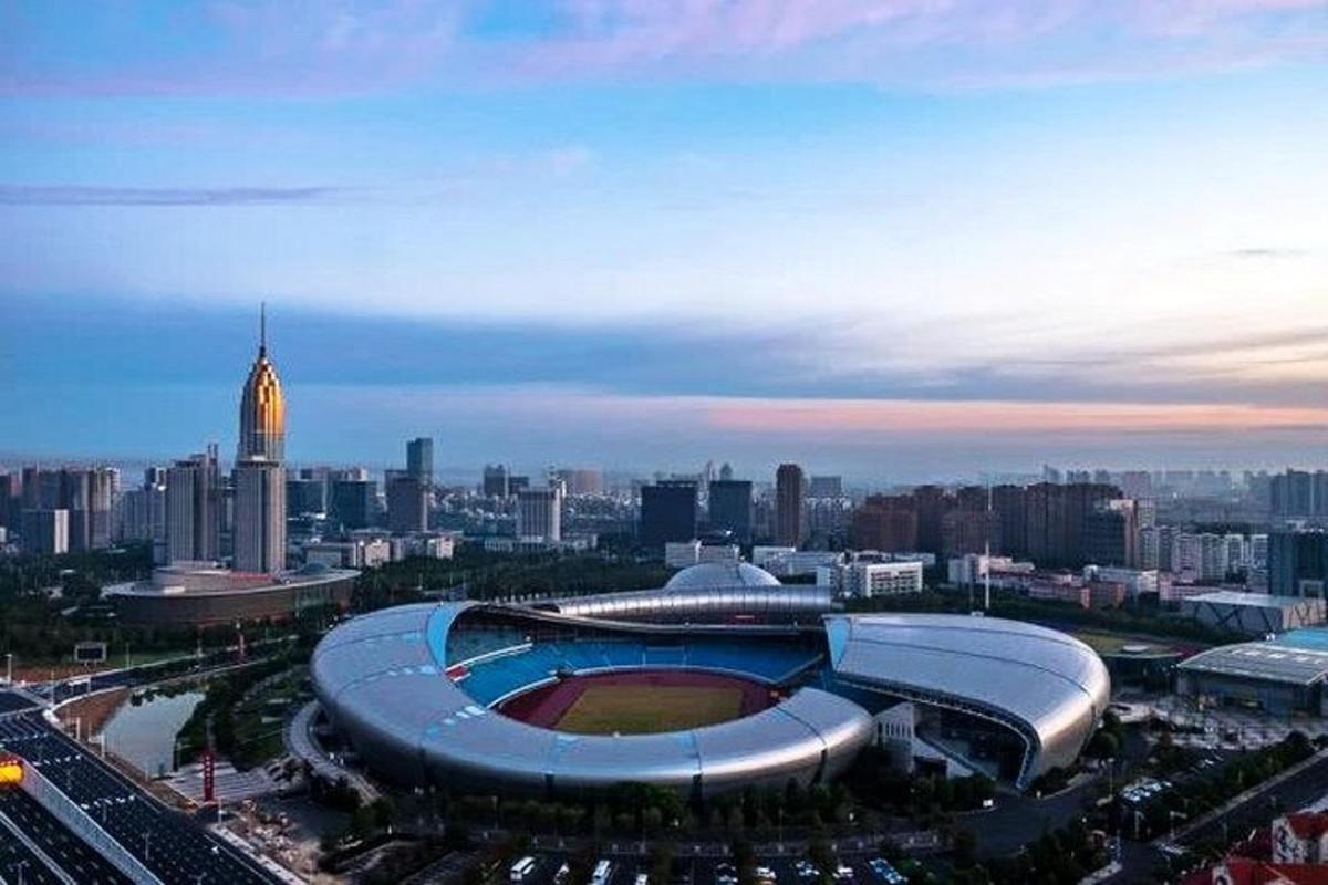a stadium with a baseball field in front of a city
