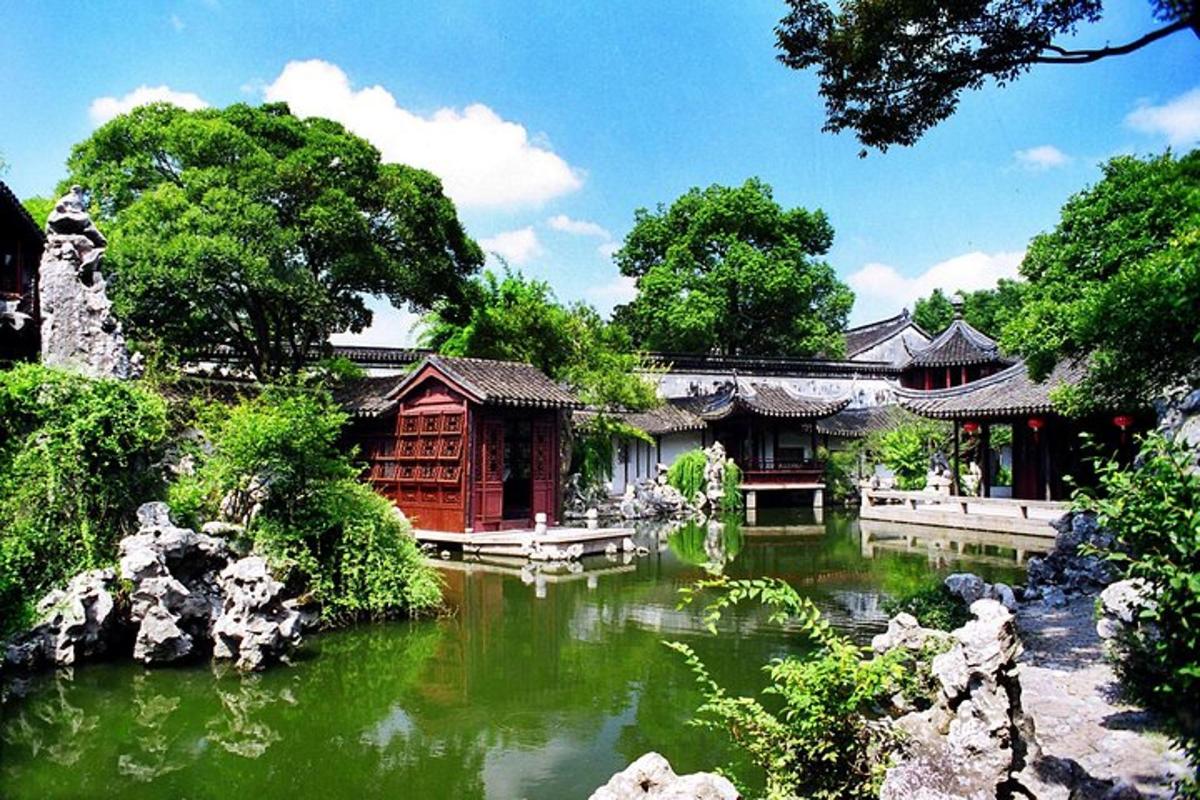 a garden with a pond in front of a building