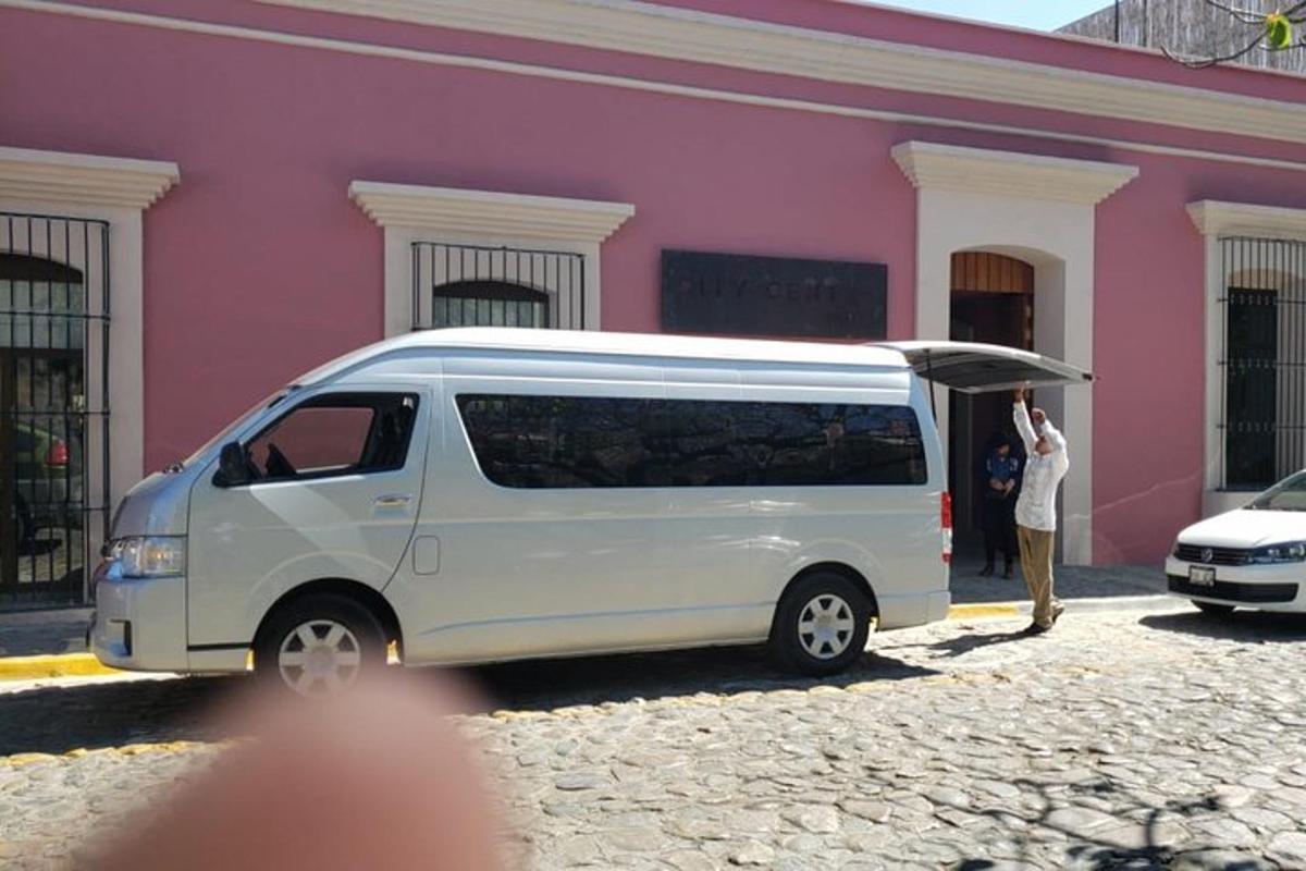 a man standing next to a white van with an umbrella