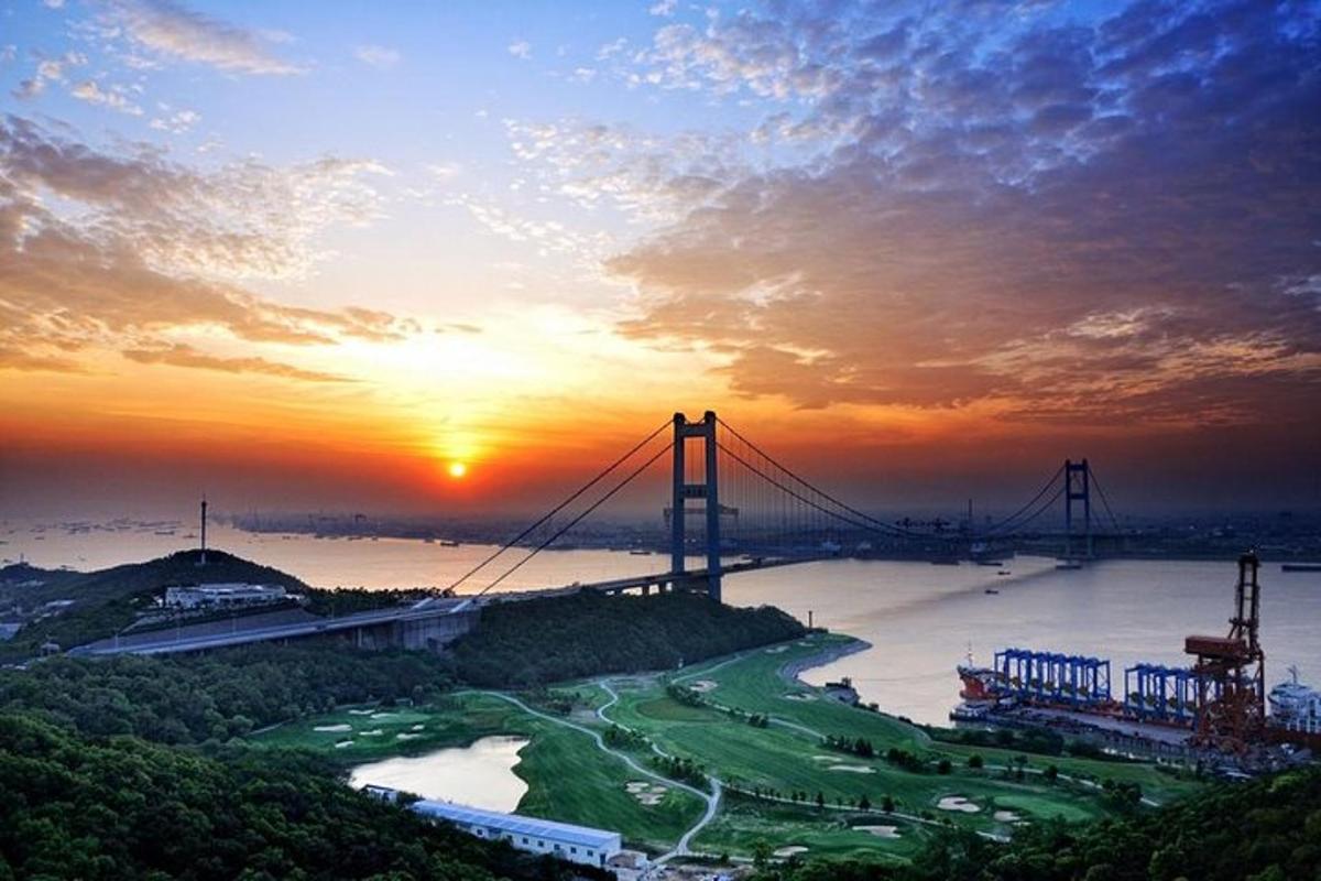 a bridge over a river with the sunset in the background