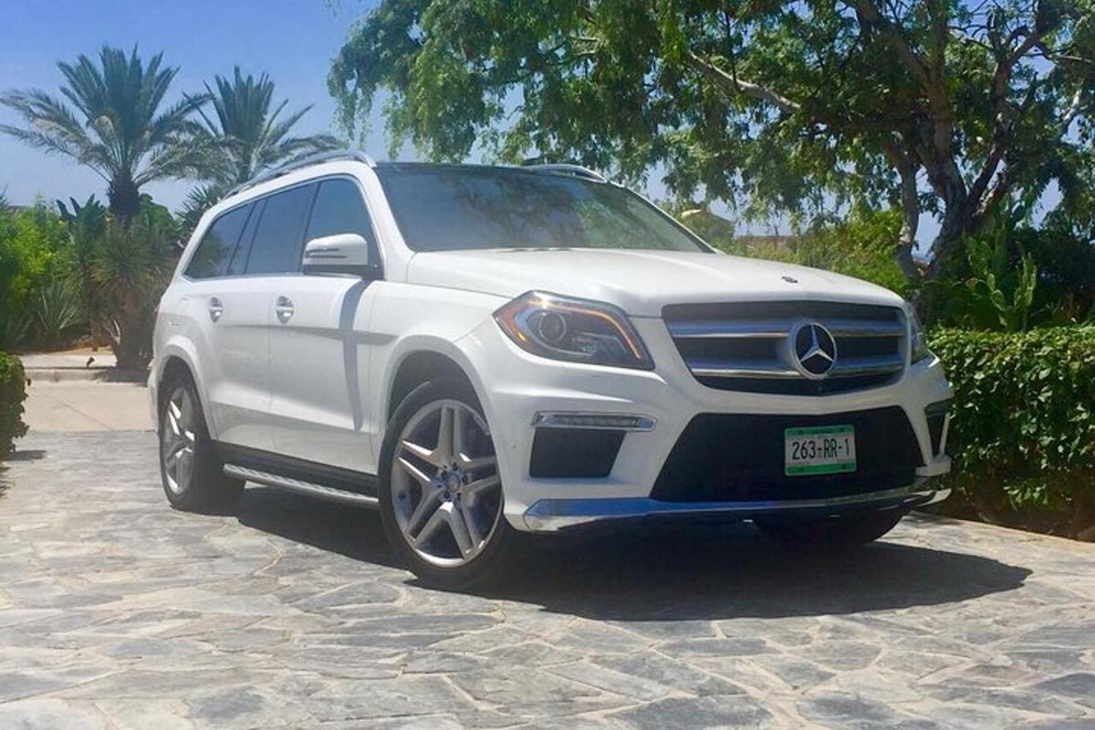 a white mercedes benz suv parked on a driveway
