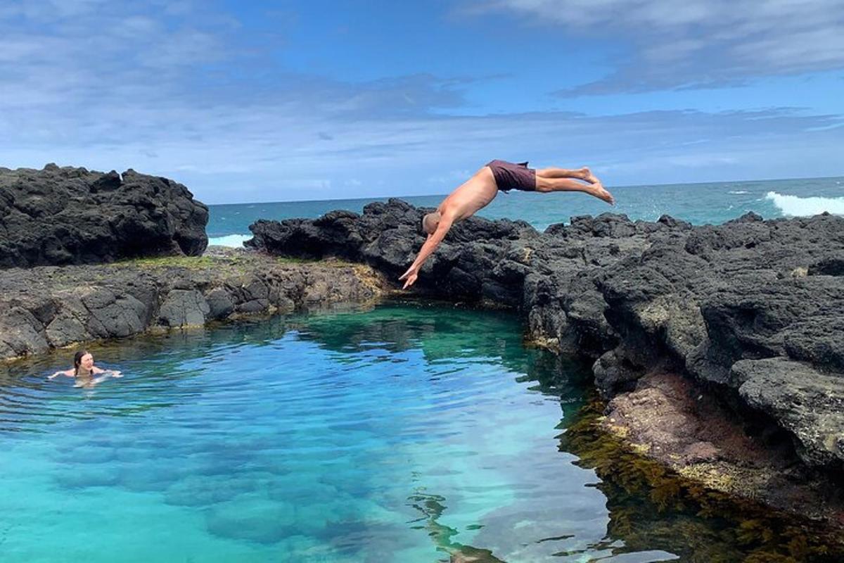 a man jumping into a body of water
