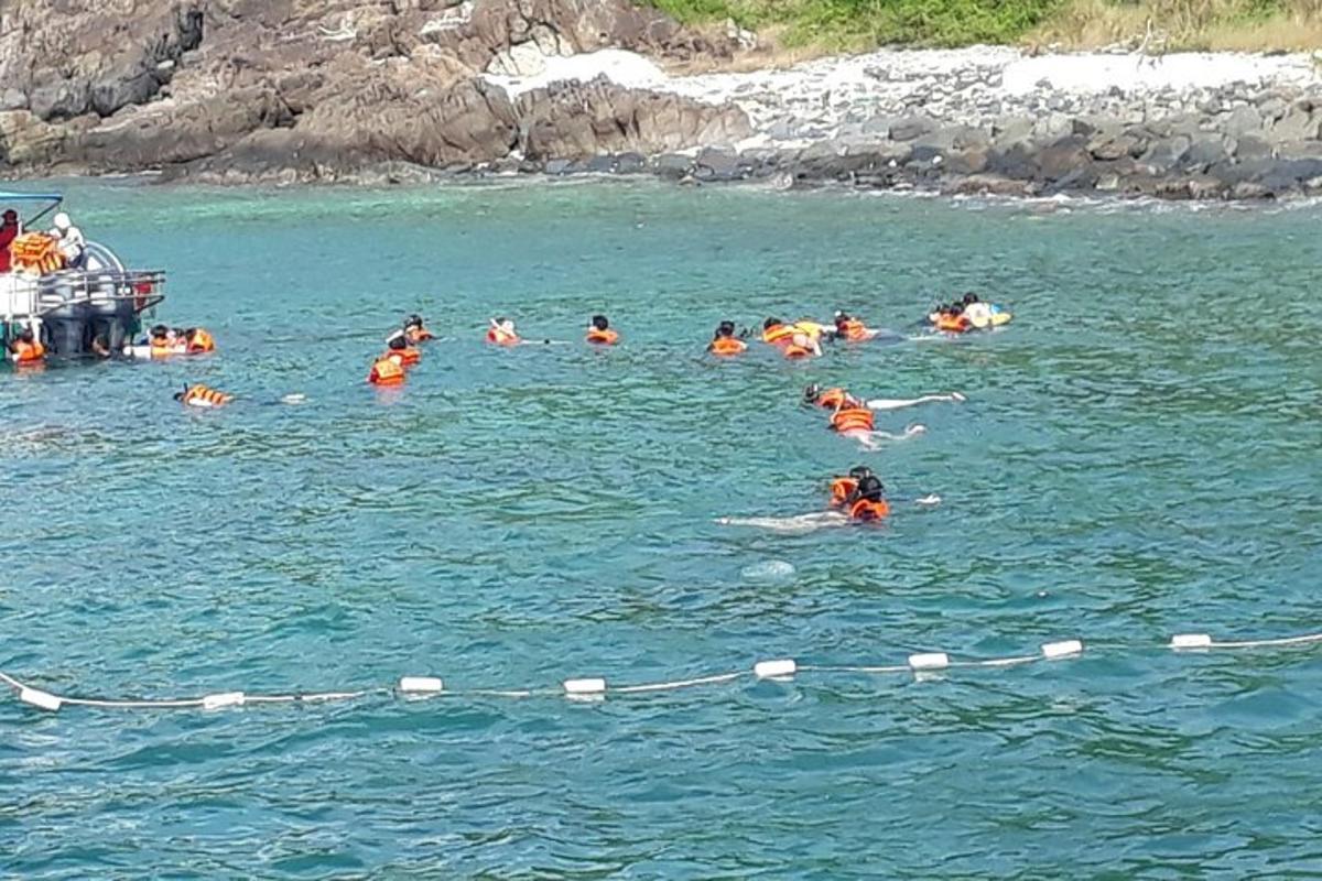 a group of people in the water near a boat