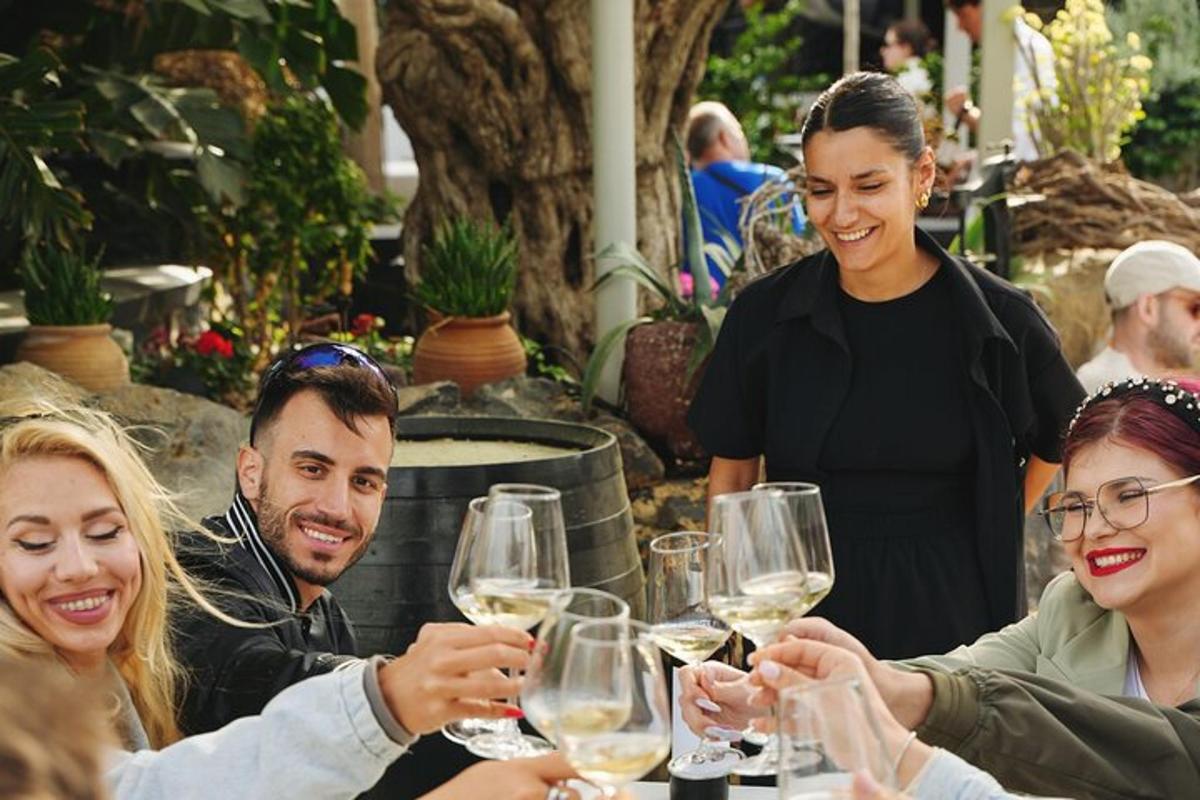 un groupe de personnes assises autour d'une table buvant du vin