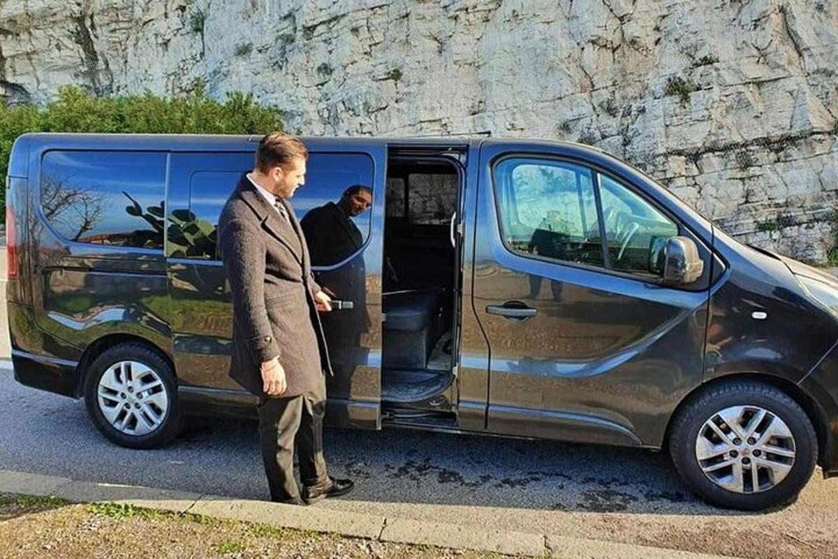 muž v obleku stojící před dodávkou