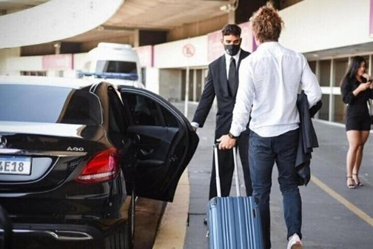 two men with a suitcase getting out of a car