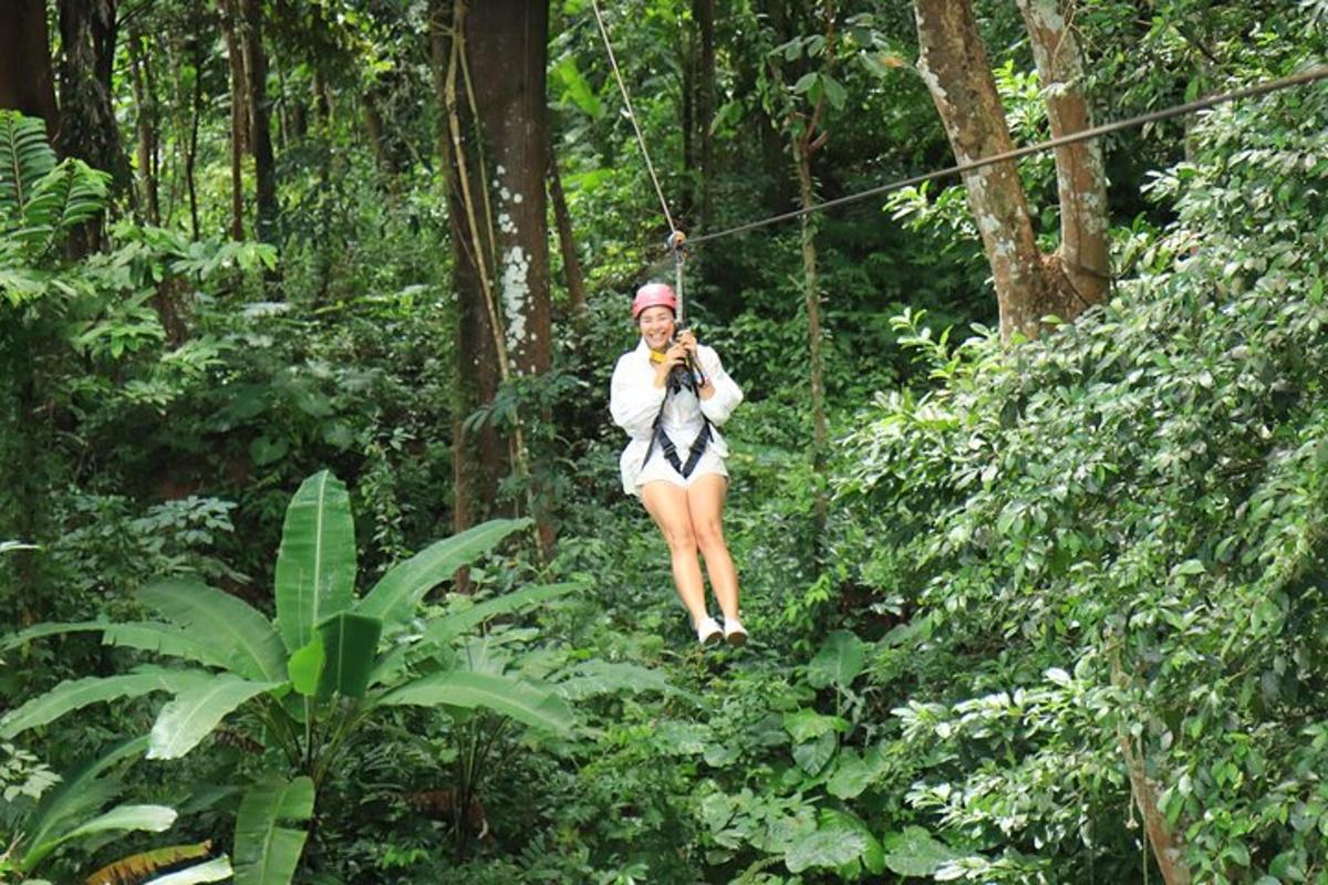 a woman swinging on a zip line in the forest