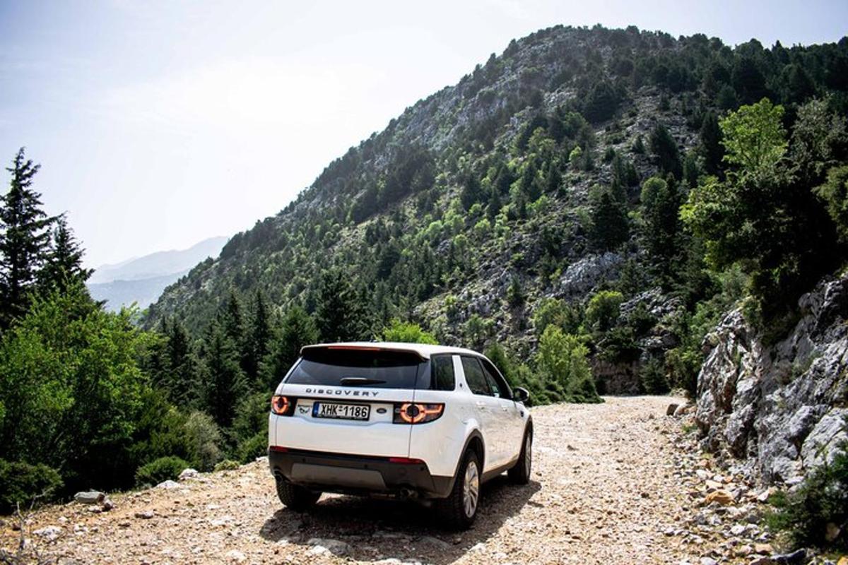 a white car parked on a rocky road in the mountains