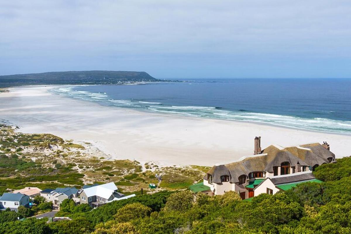 a house on a hill next to a beach