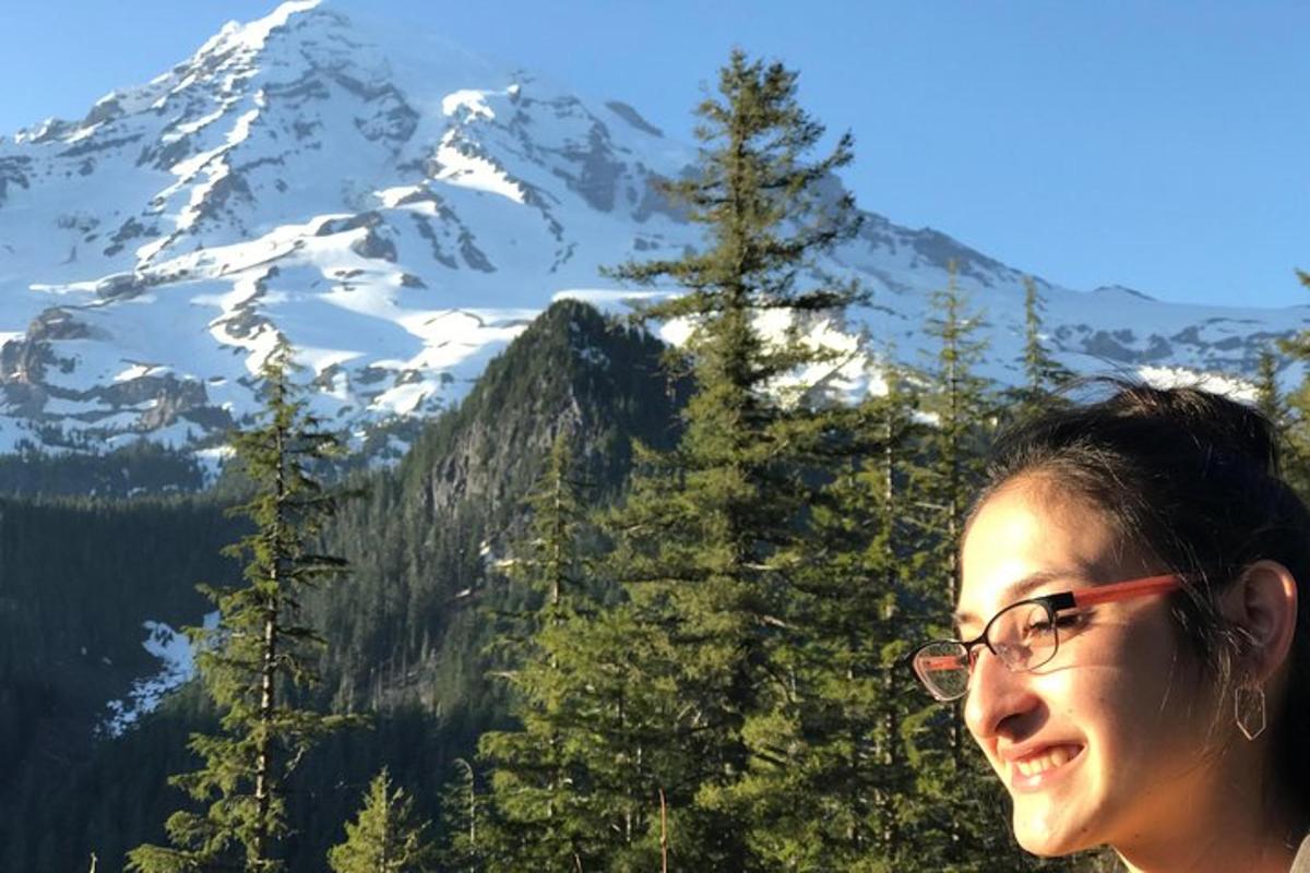 una donna in piedi davanti a una montagna coperta di neve