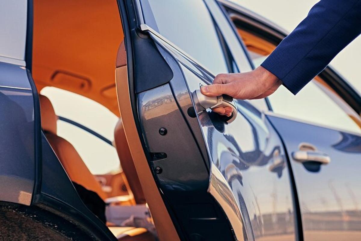 Un hombre está abriendo la puerta de un coche.