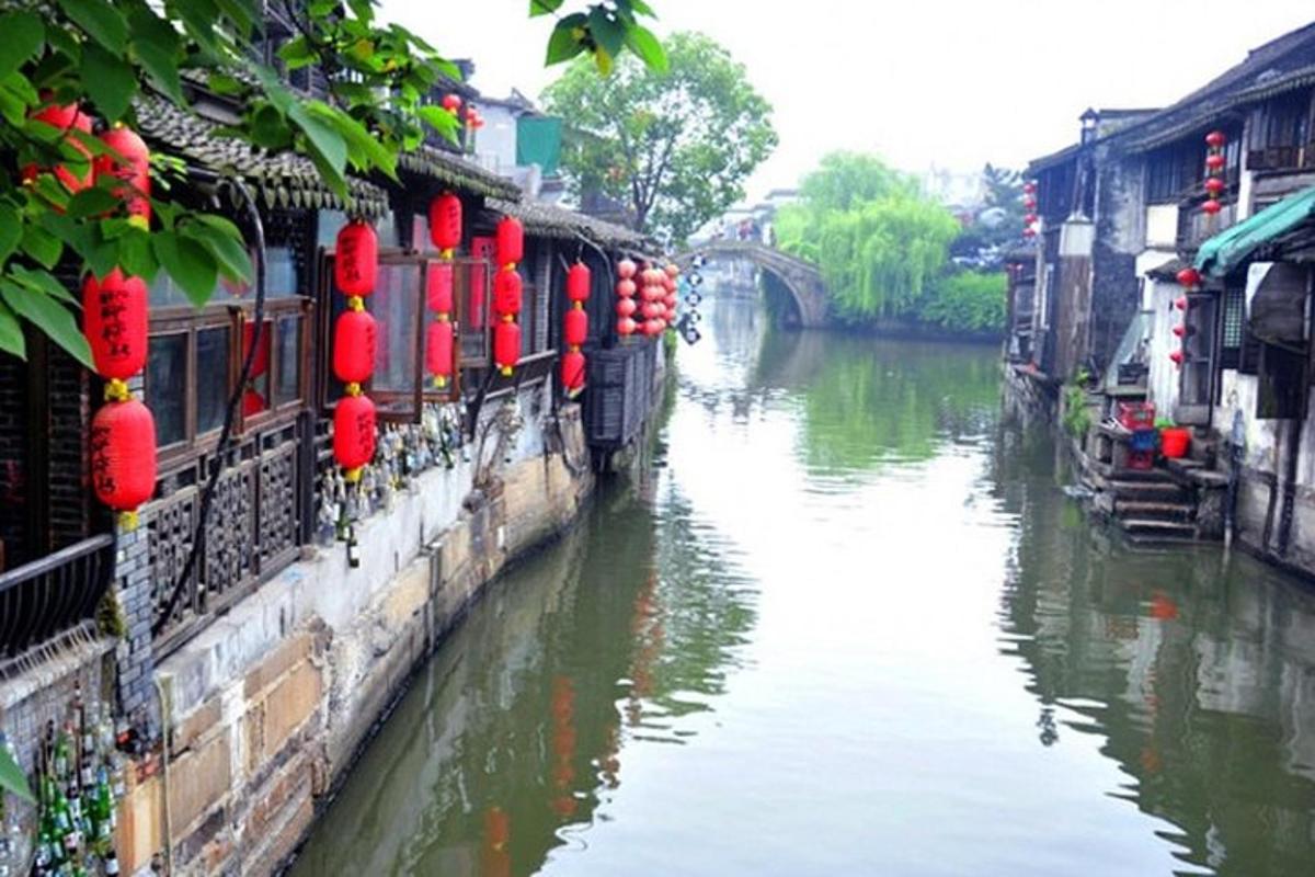 Un río con faroles rojos en los costados de los edificios.