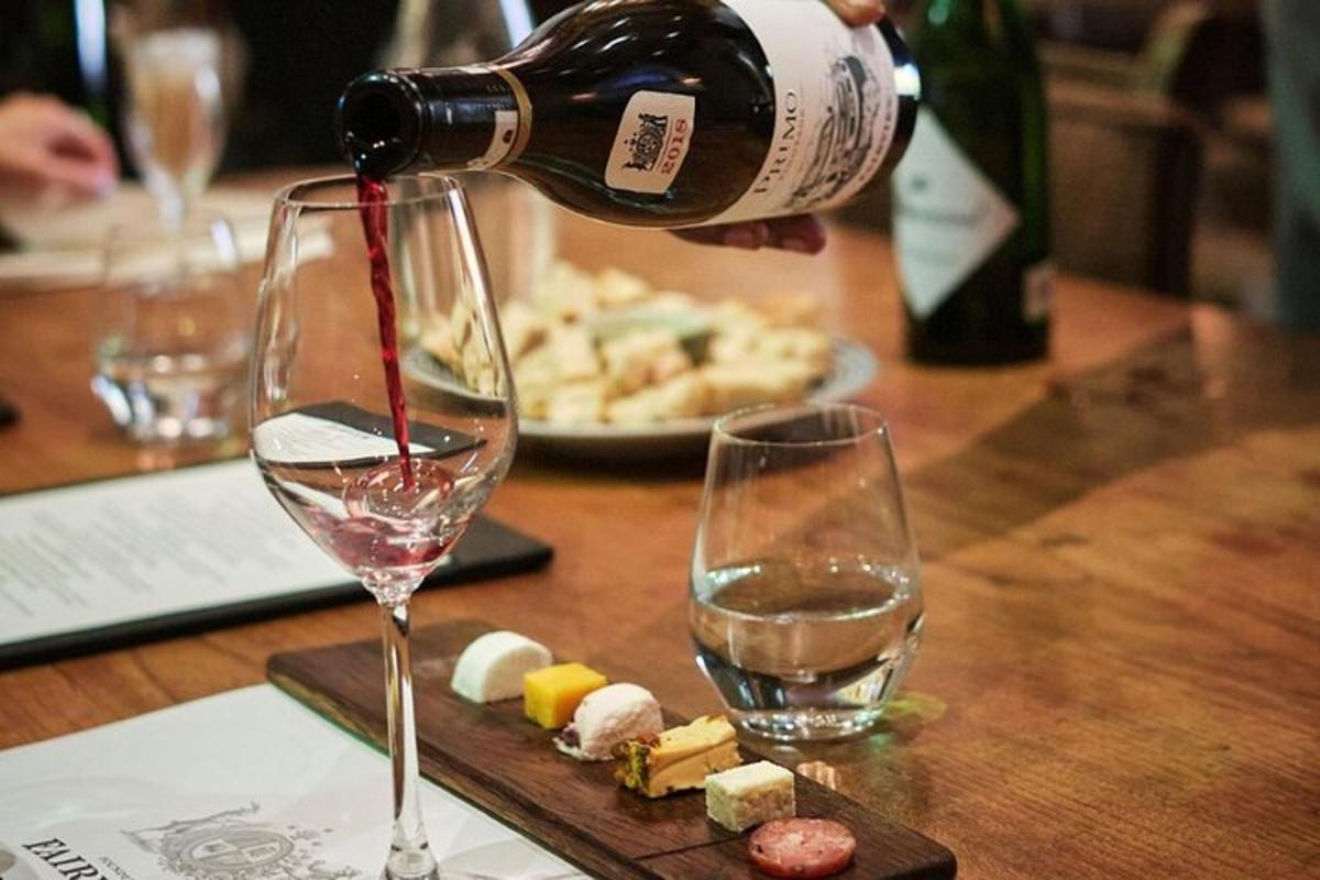 a person pouring wine into a glass on a table