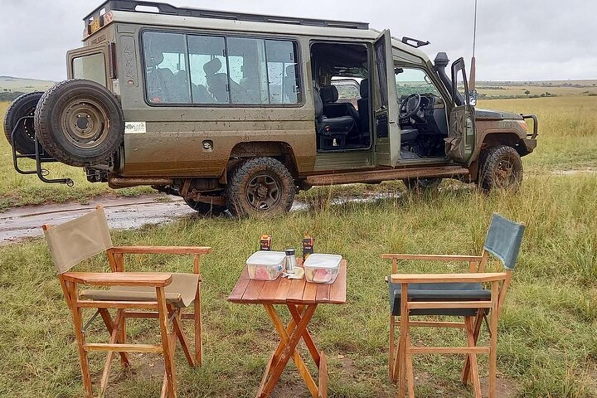 un jeep parcat pe un câmp cu două scaune și o masă