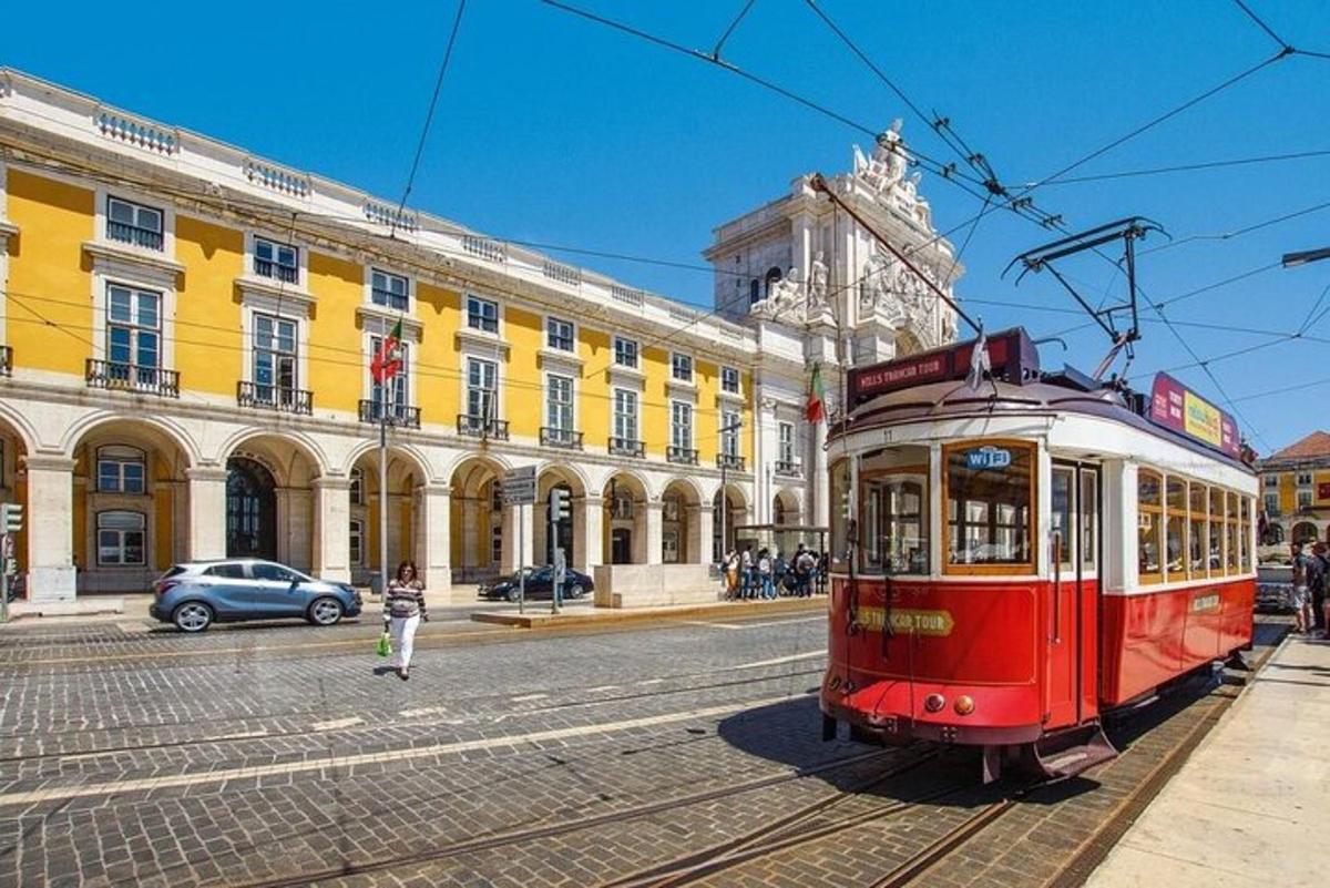 ένα κόκκινο τραμ σε έναν δρόμο μπροστά από ένα κτίριο