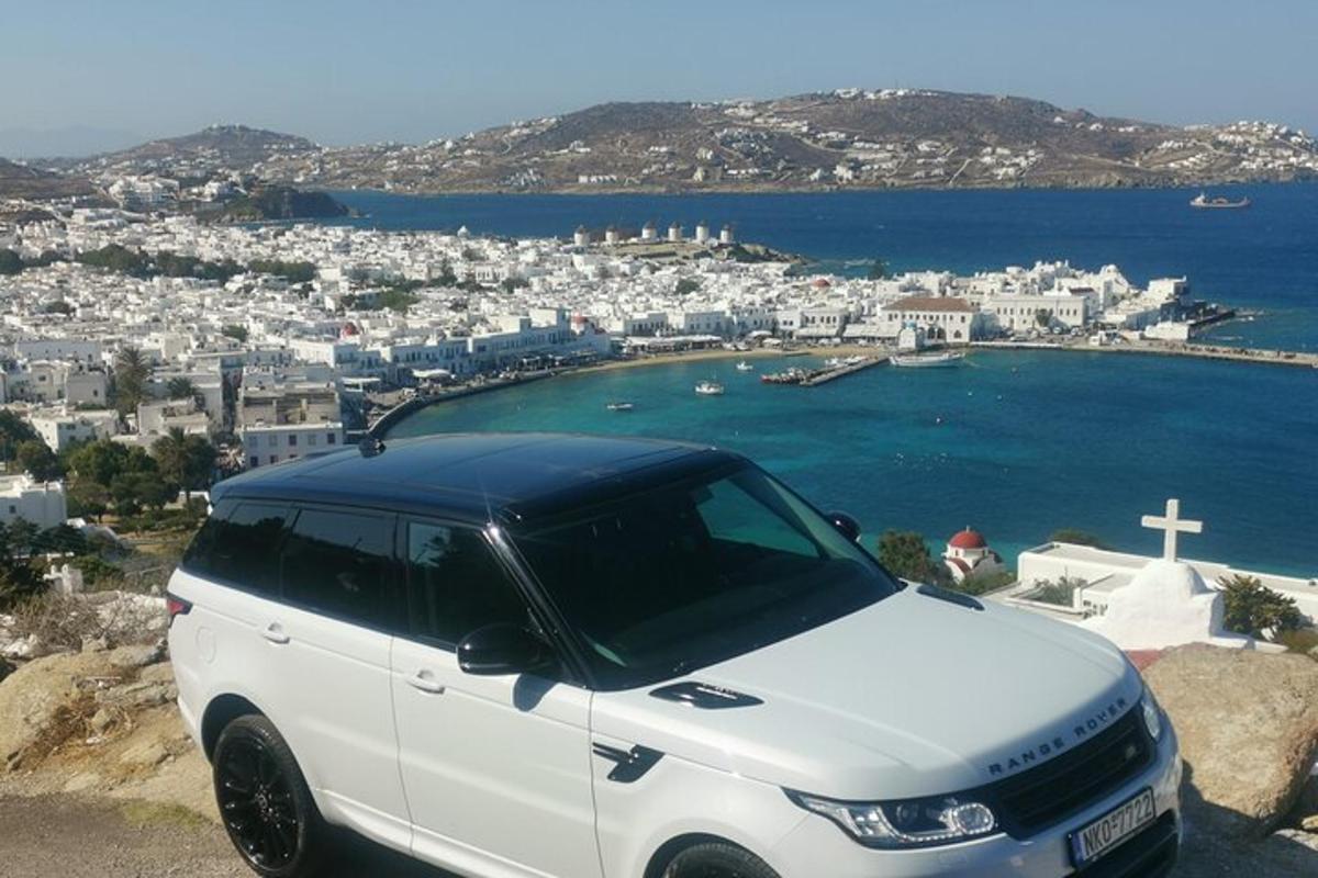 a white car parked on top of a hill with a cross
