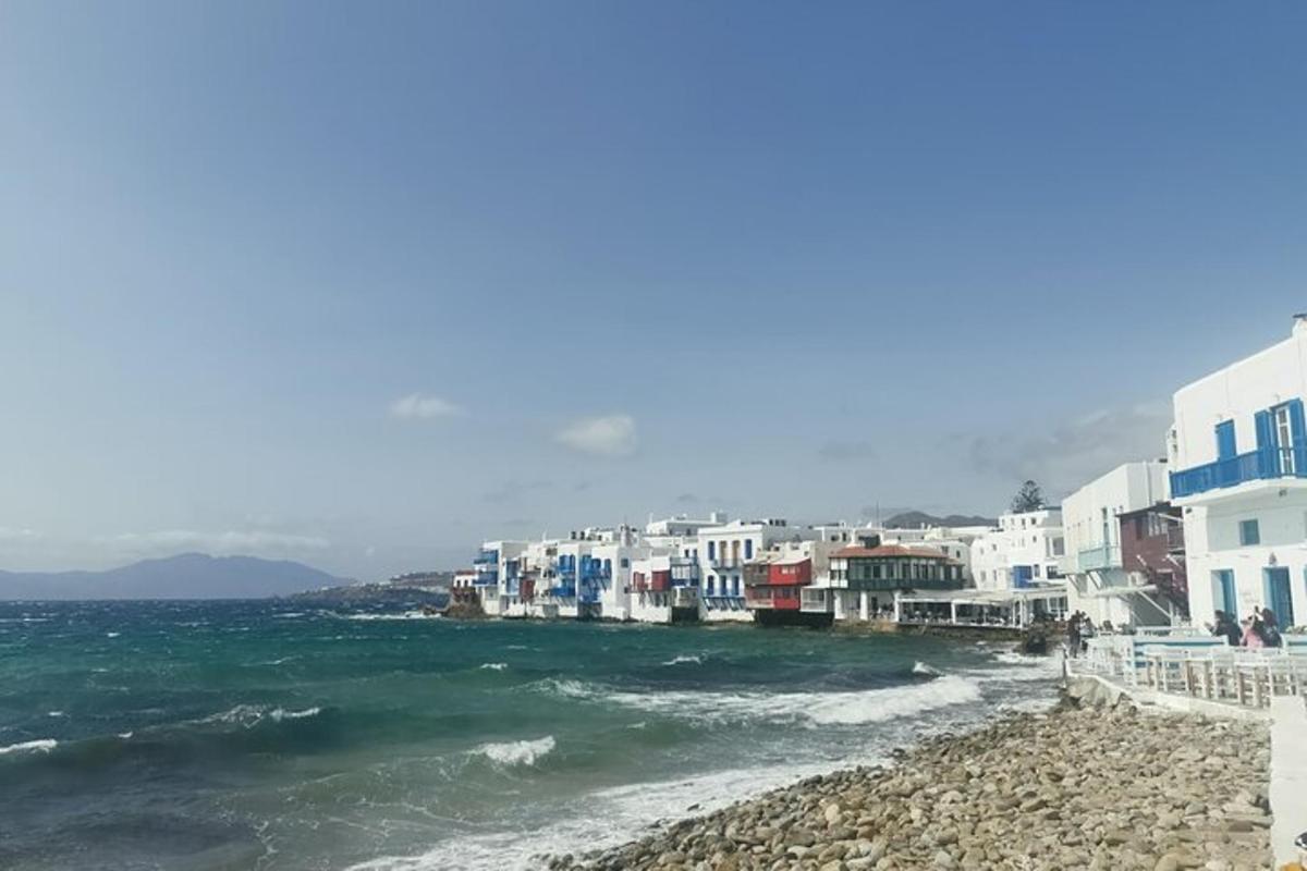 a group of buildings on a beach next to the water