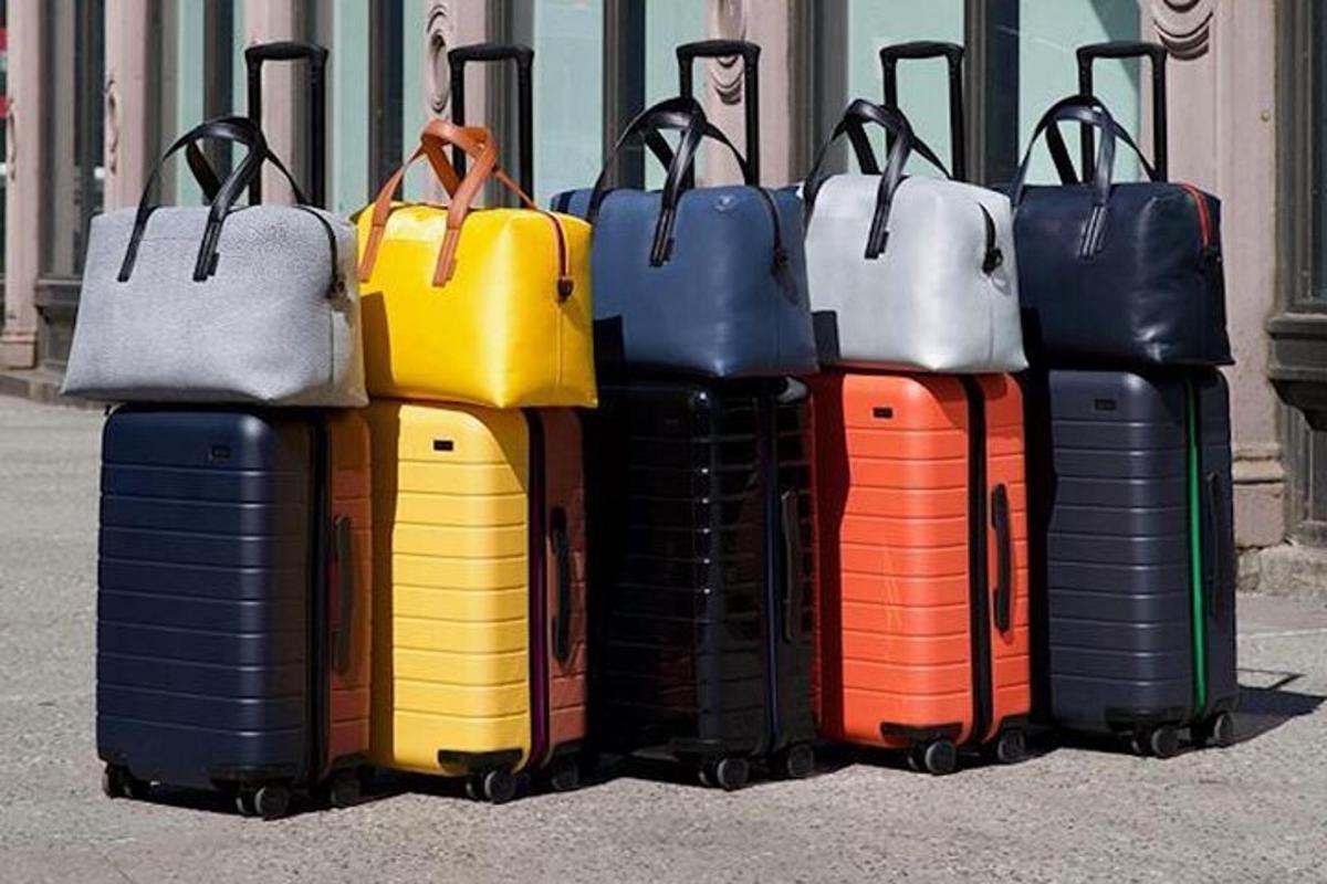 a group of different colored suitcases sitting on the ground