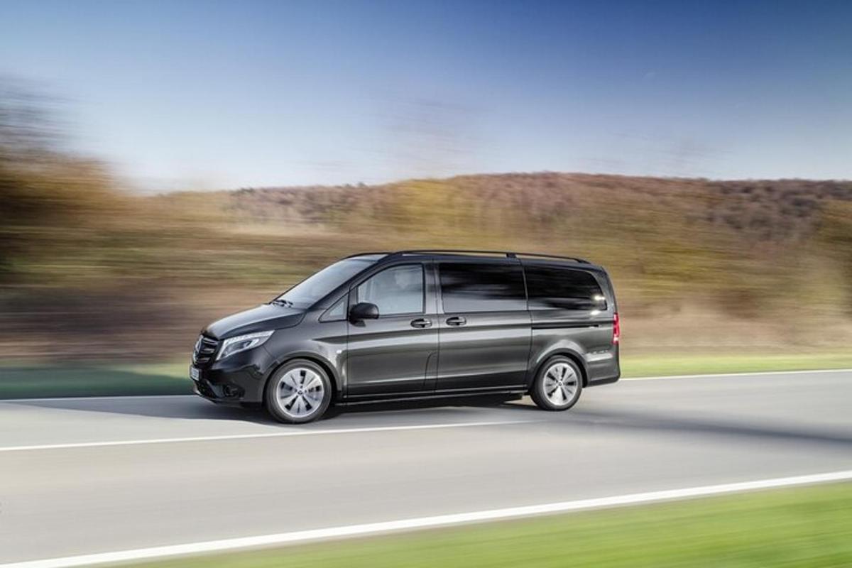 una minivan platejada conduint per una carretera