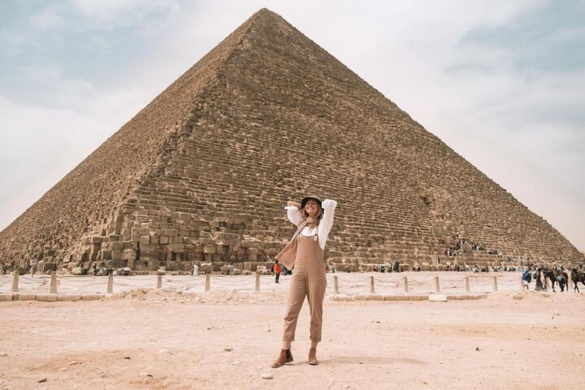 nainen seisoo pyramidin edessä