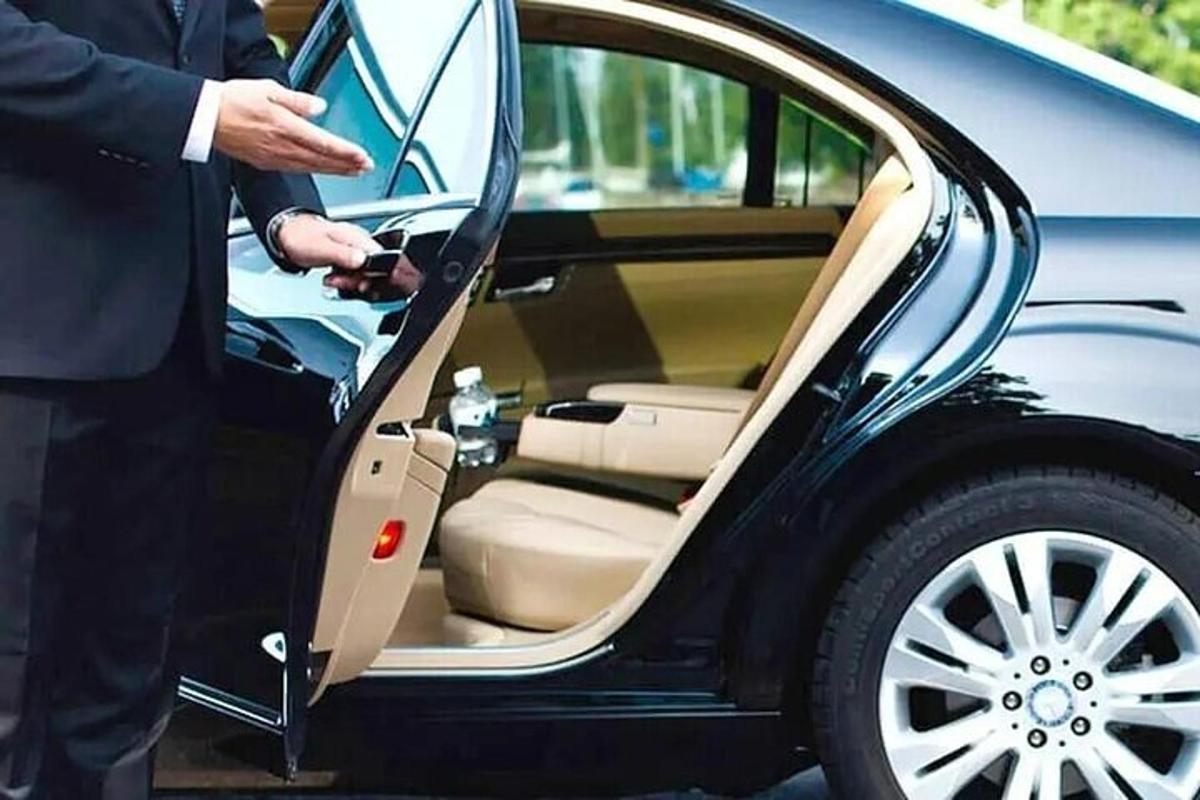 Un hombre está abriendo la puerta de un coche.