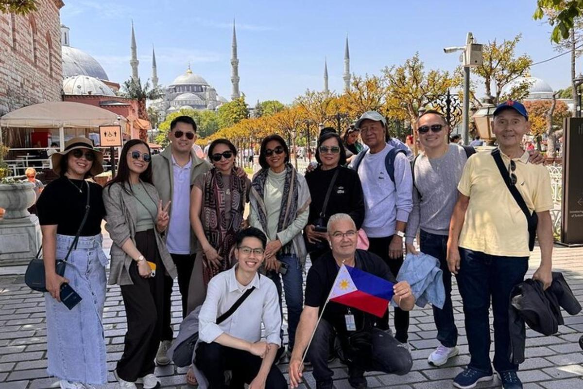 Un grupo de personas posando para una foto frente a una mezquita.