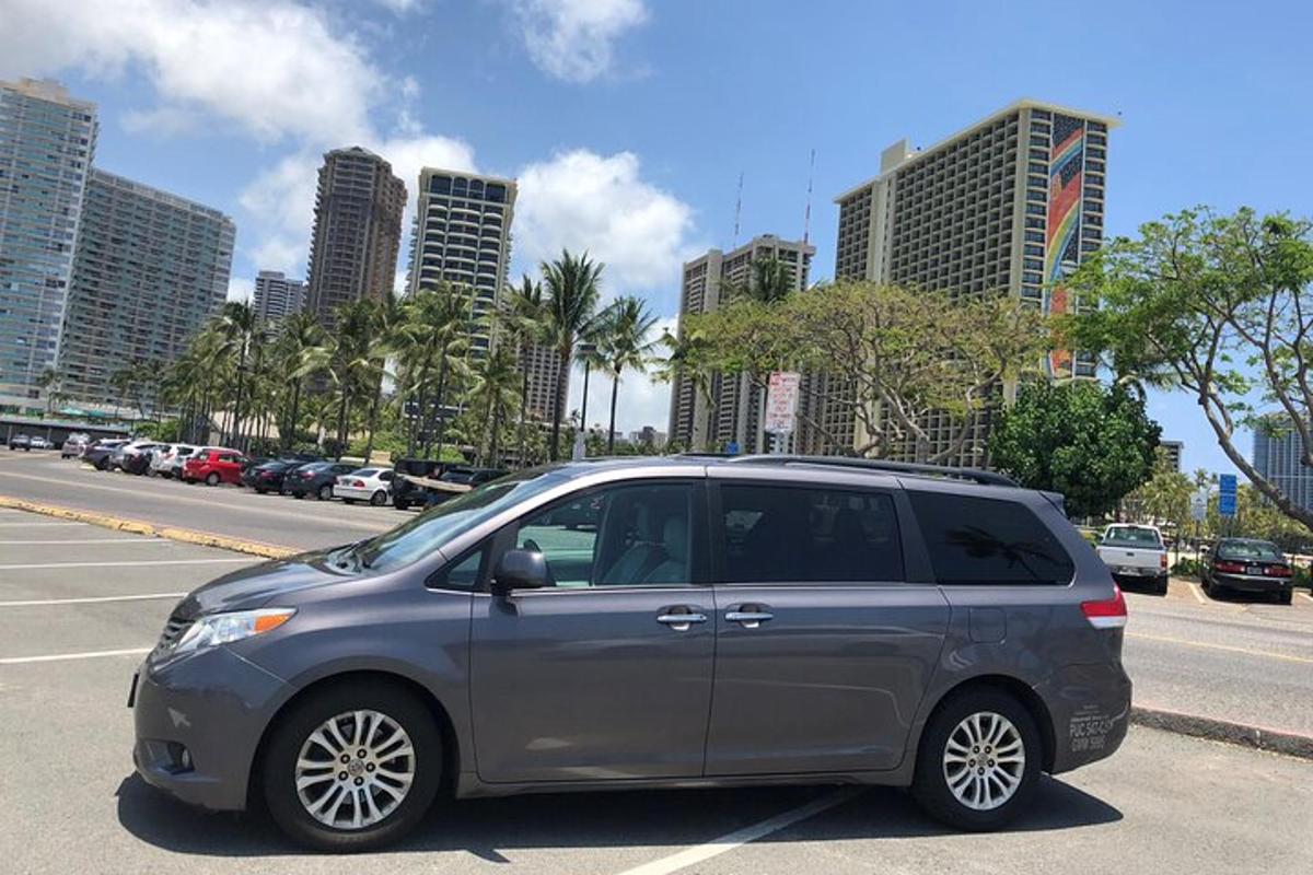 una minivan platejada aparcada en un aparcament amb edificis