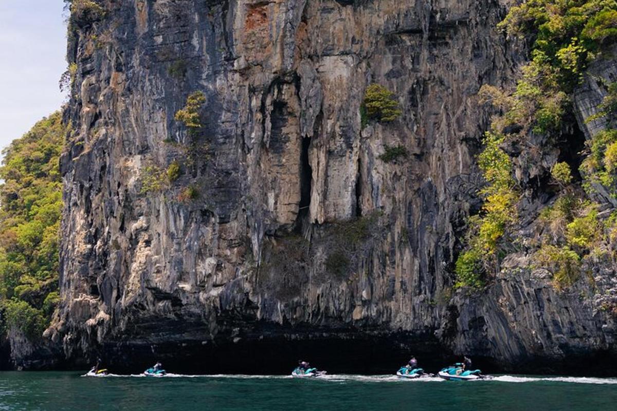 Personas en botes en el agua cerca de una montaña