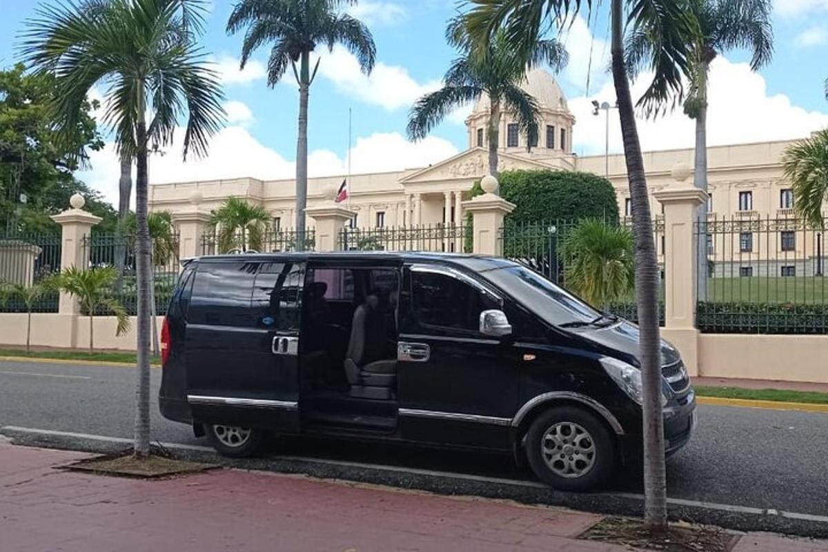 sebuah van hitam berhenti di hadapan sebuah bangunan dengan pokok palma