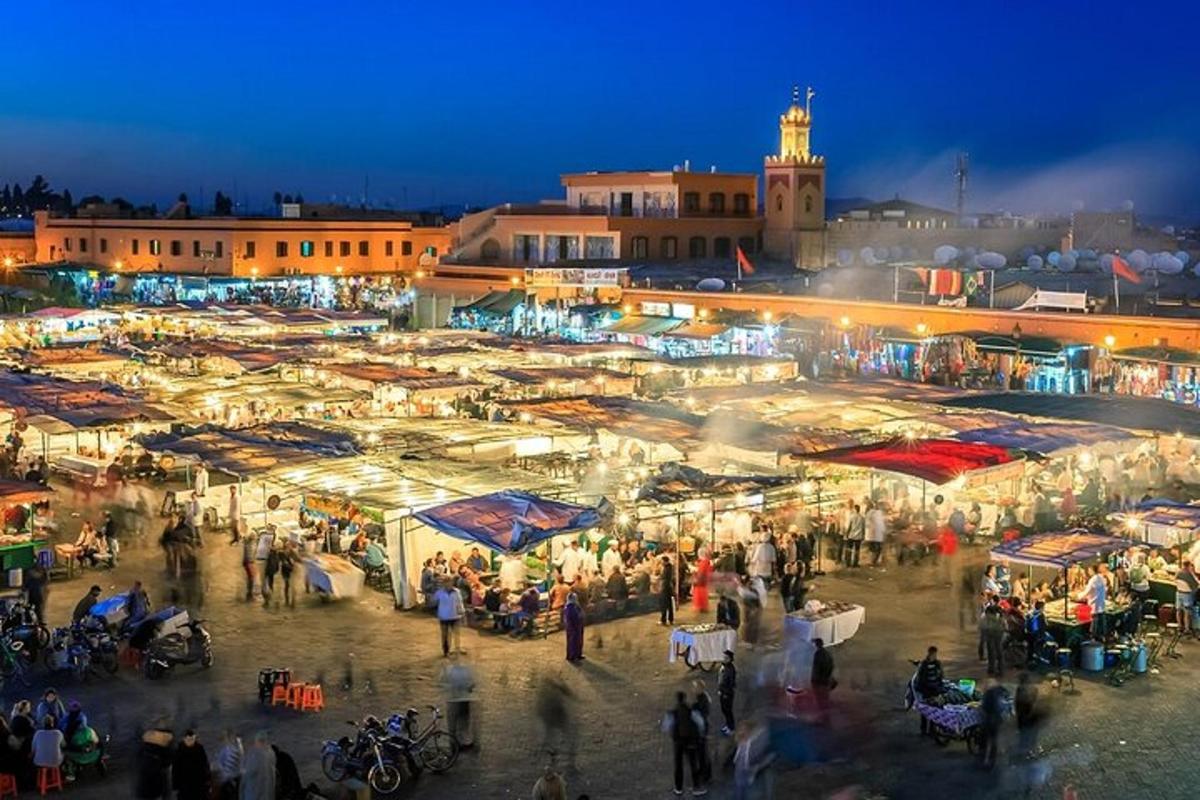 uma multidão de pessoas caminhando ao redor de um mercado à noite