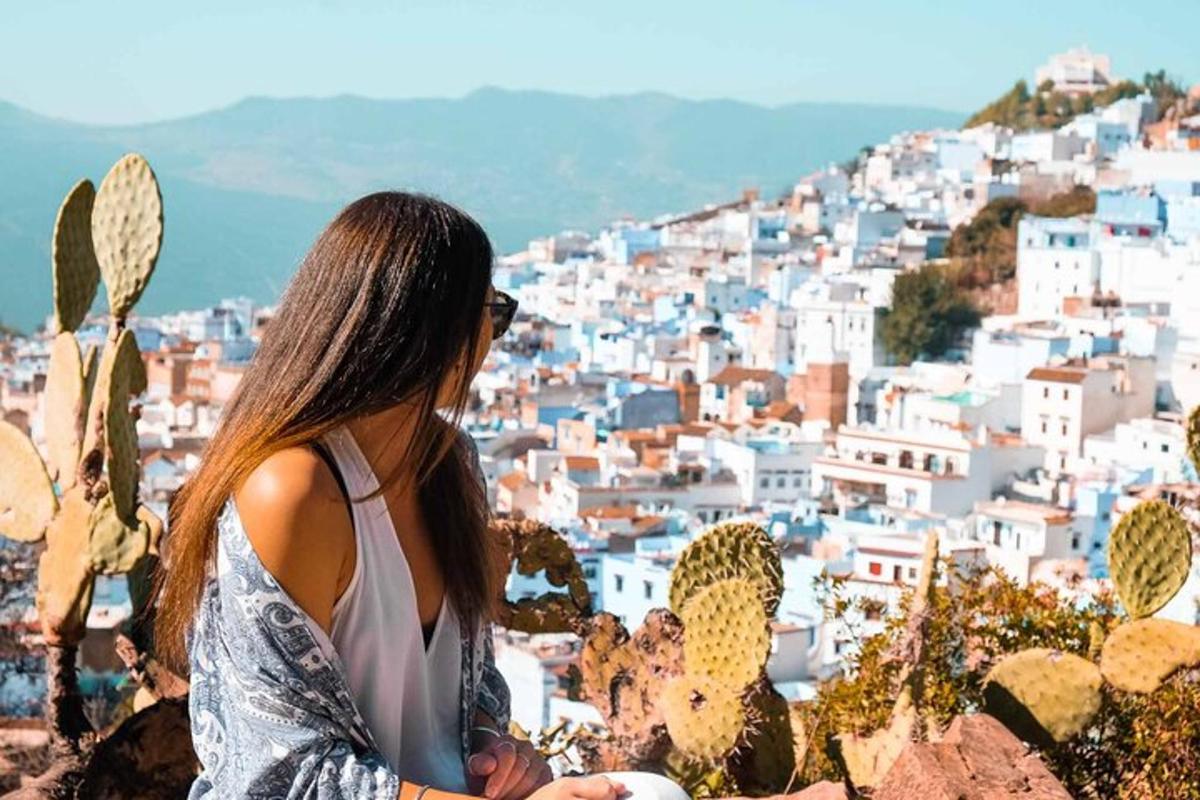 uma mulher parada em uma colina olhando para uma cidade