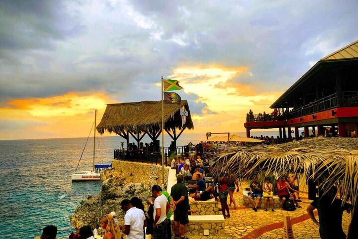 sekumpulan orang berdiri di pantai berhampiran lautan
