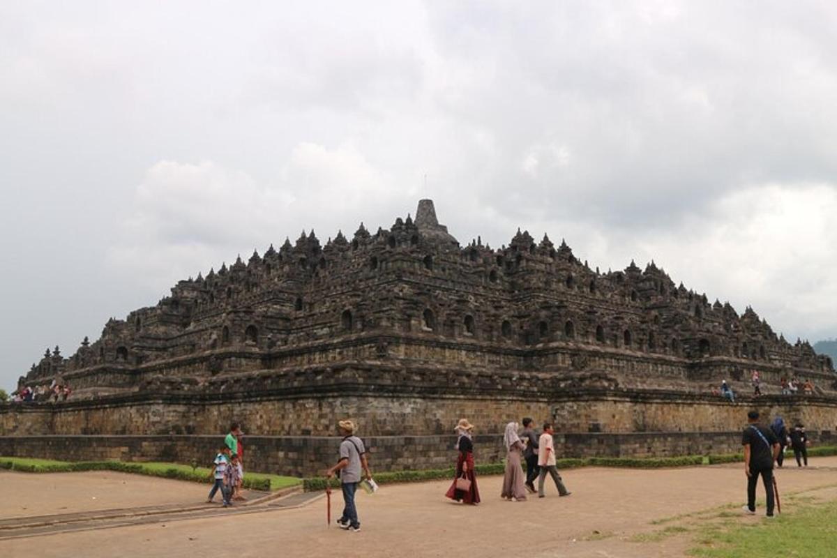 a group of people walking in front of a large stone building