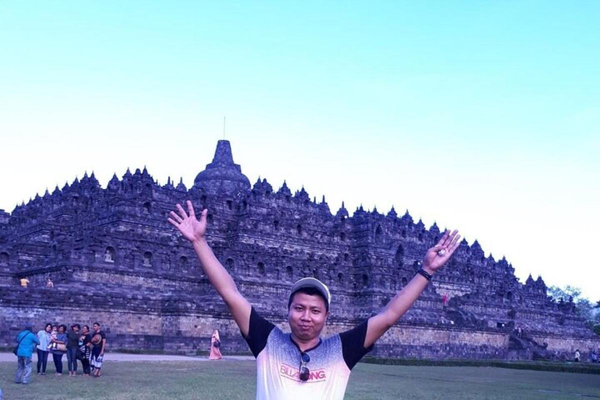a man with his arms up in front of a building