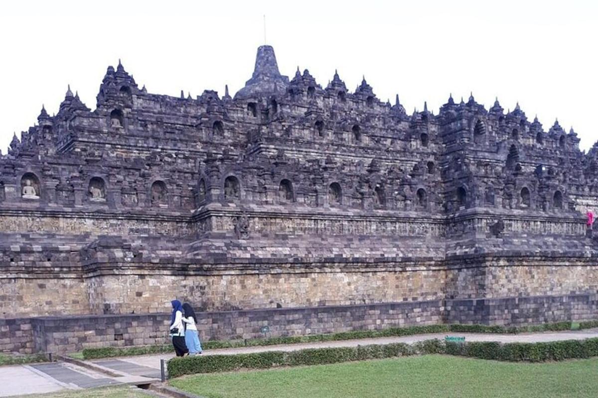 a person standing in front of a large stone building