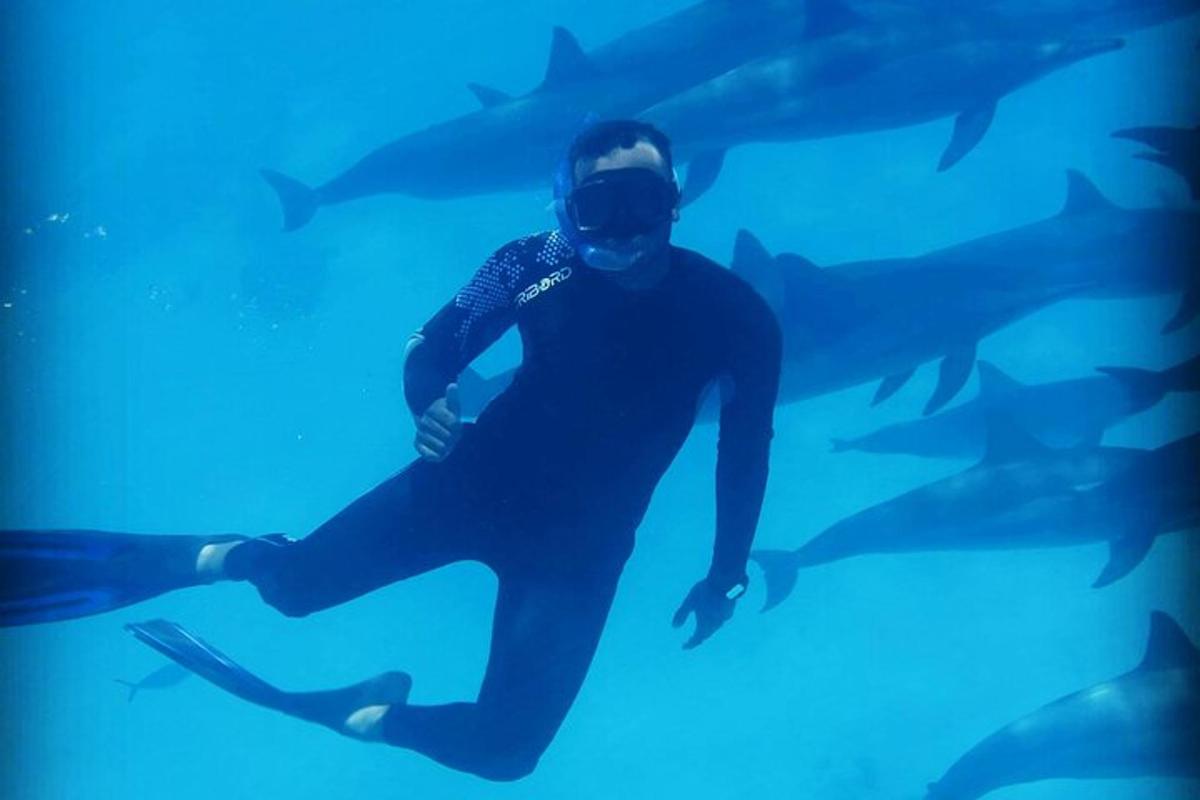 a man in a wetsuit swimming in an aquarium