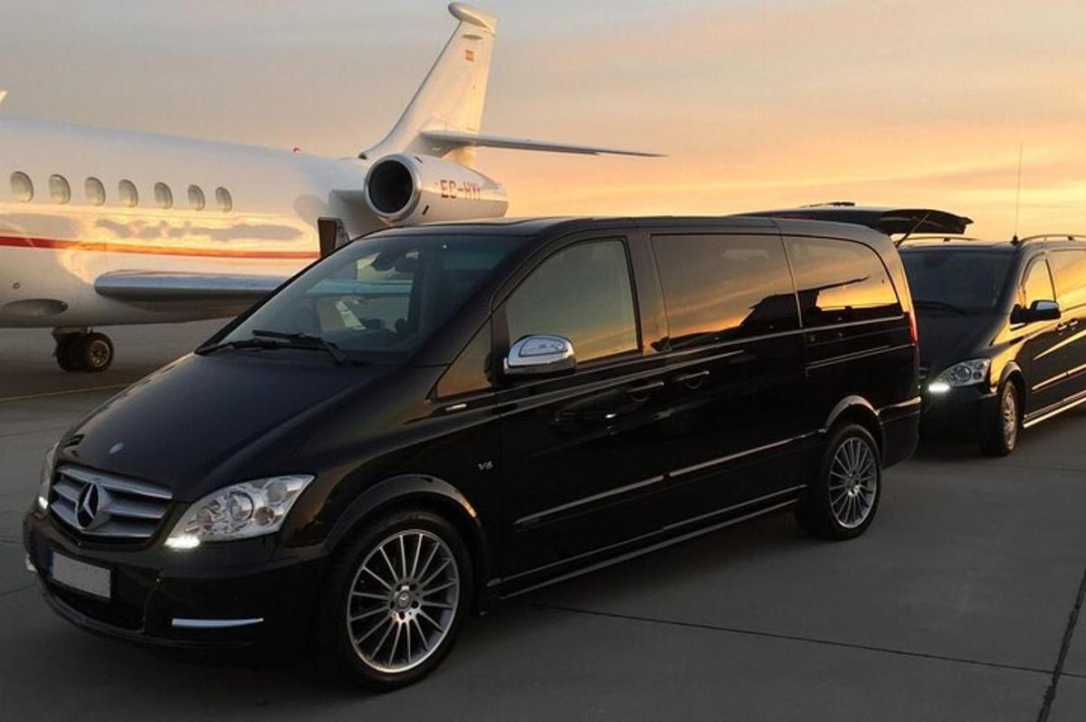 Una camioneta negra está estacionada al lado de un avión