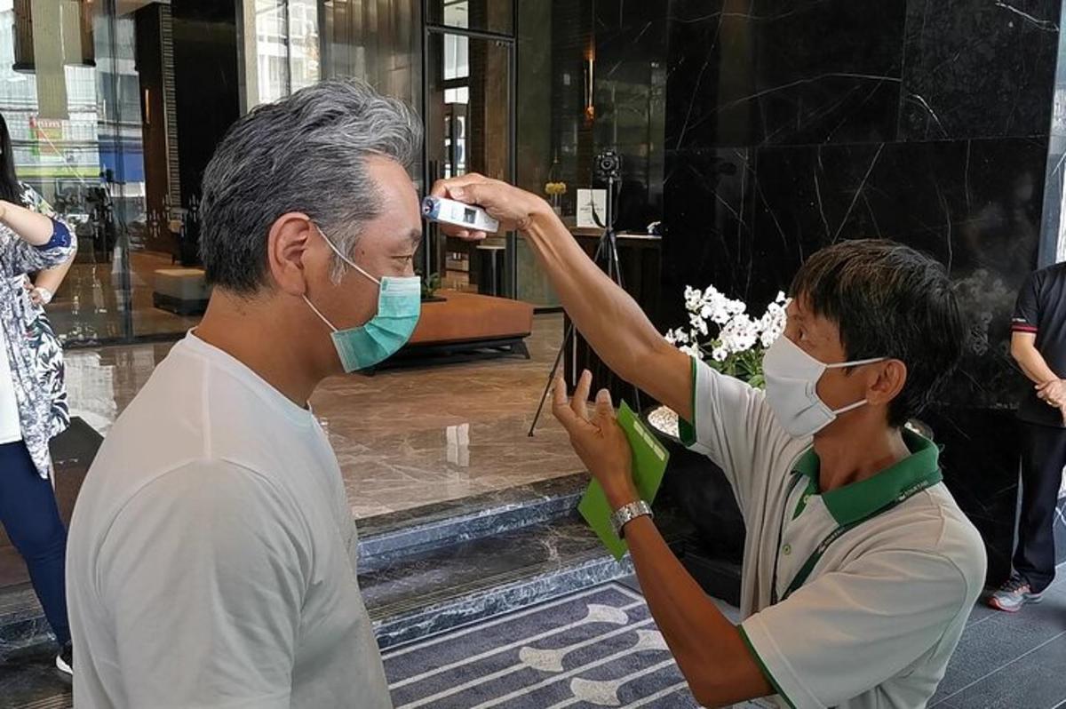 muž fotografujúci ženu s rúškom