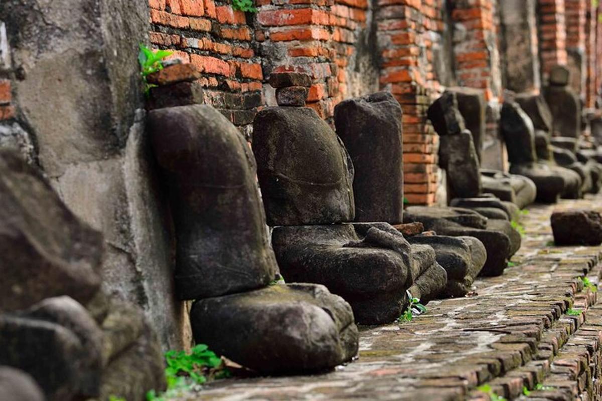 una fila de estatuas alineadas contra una pared de ladrillos
