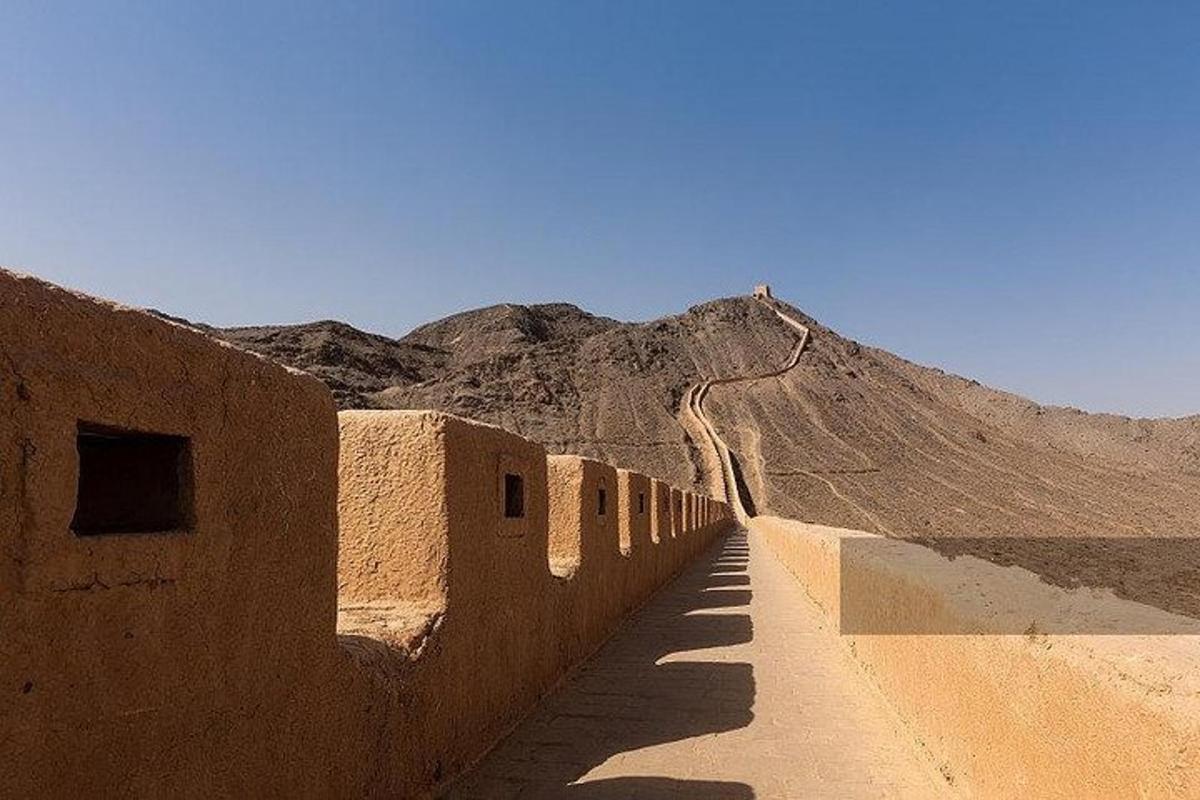 a dirt road in the desert with a mountain in the background