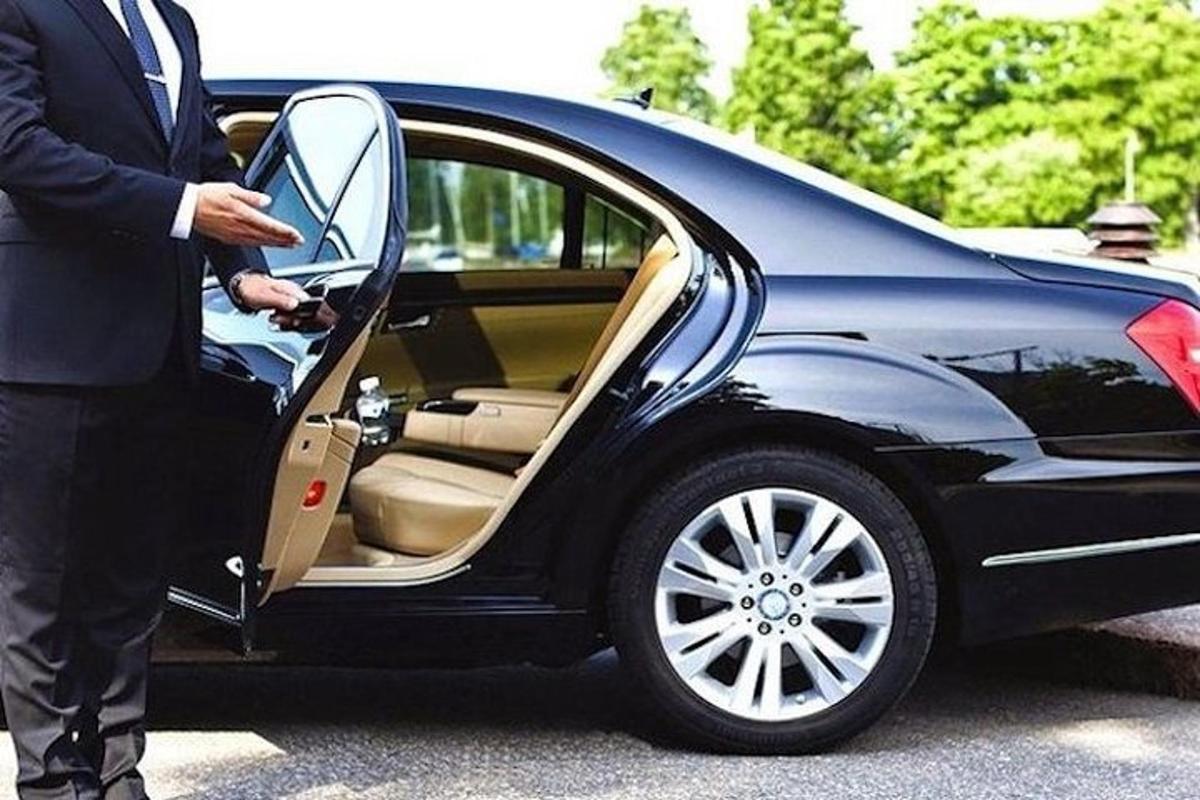 a man opening the door of a black car